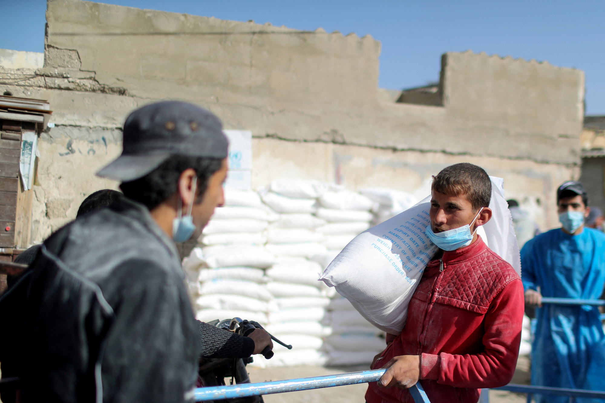 עובד פלסטיני נושא שקית קמח מחוץ למרכז חלוקת סיוע בעיר עזה ב-7 באפריל.