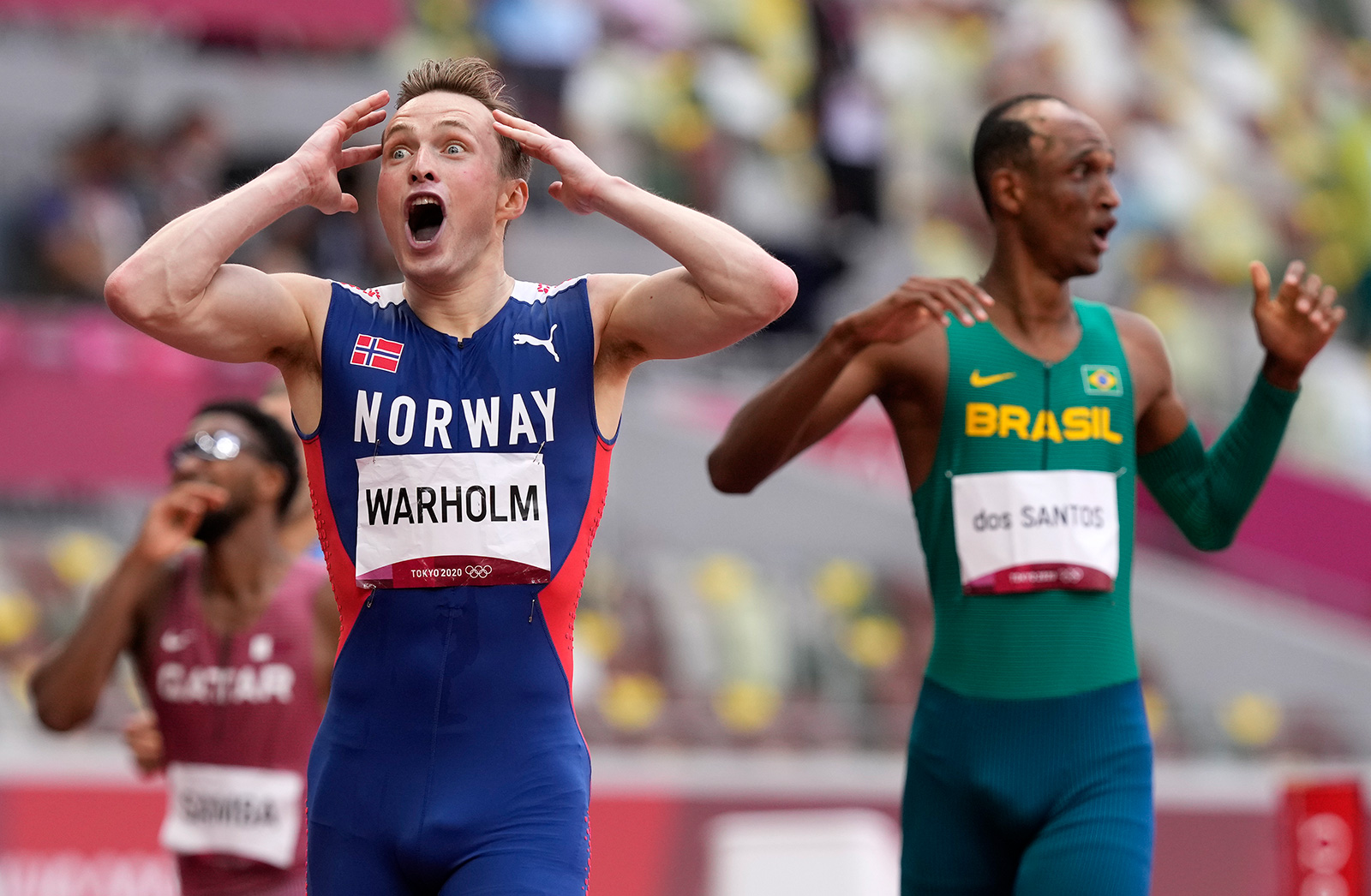 Norway's Karsten Warholm celebrates after winning the gold medal and breaking a world record in the 400 meter hurdles final on Tuesday.
