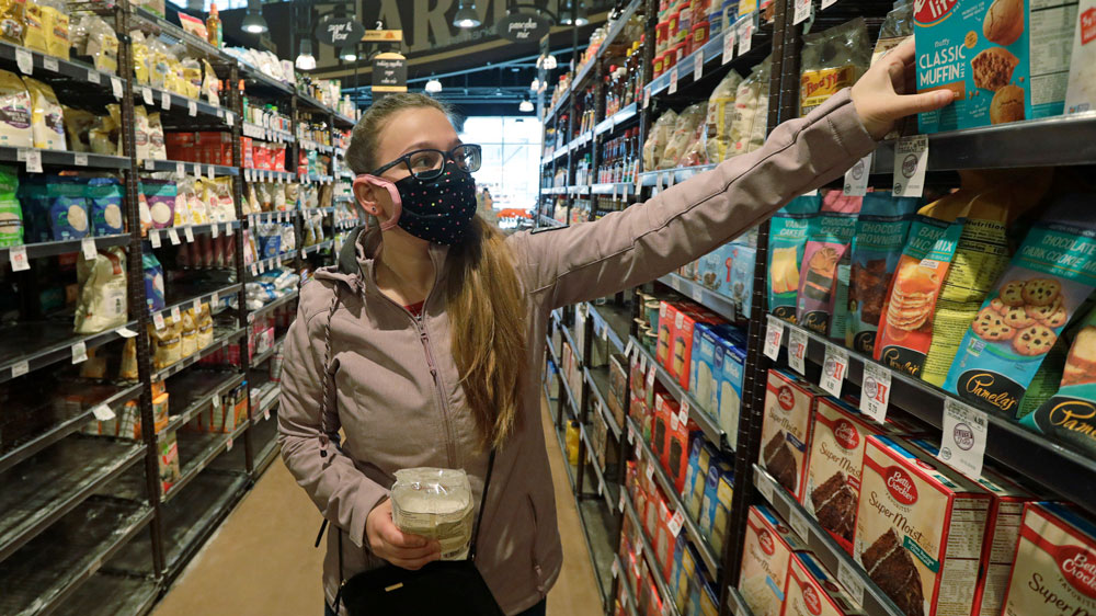 A customer wears a mask as she shops for groceries on Friday, April 3, in Salt Lake City.