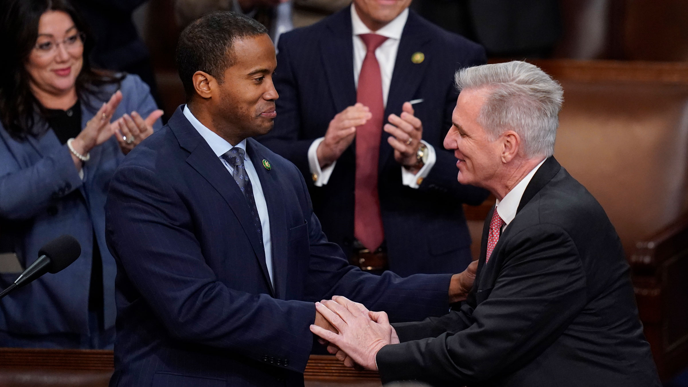U.S. Representative-elect John James, left, shakes hands with Kevin McCarthy after nominating him for president on Thursday.