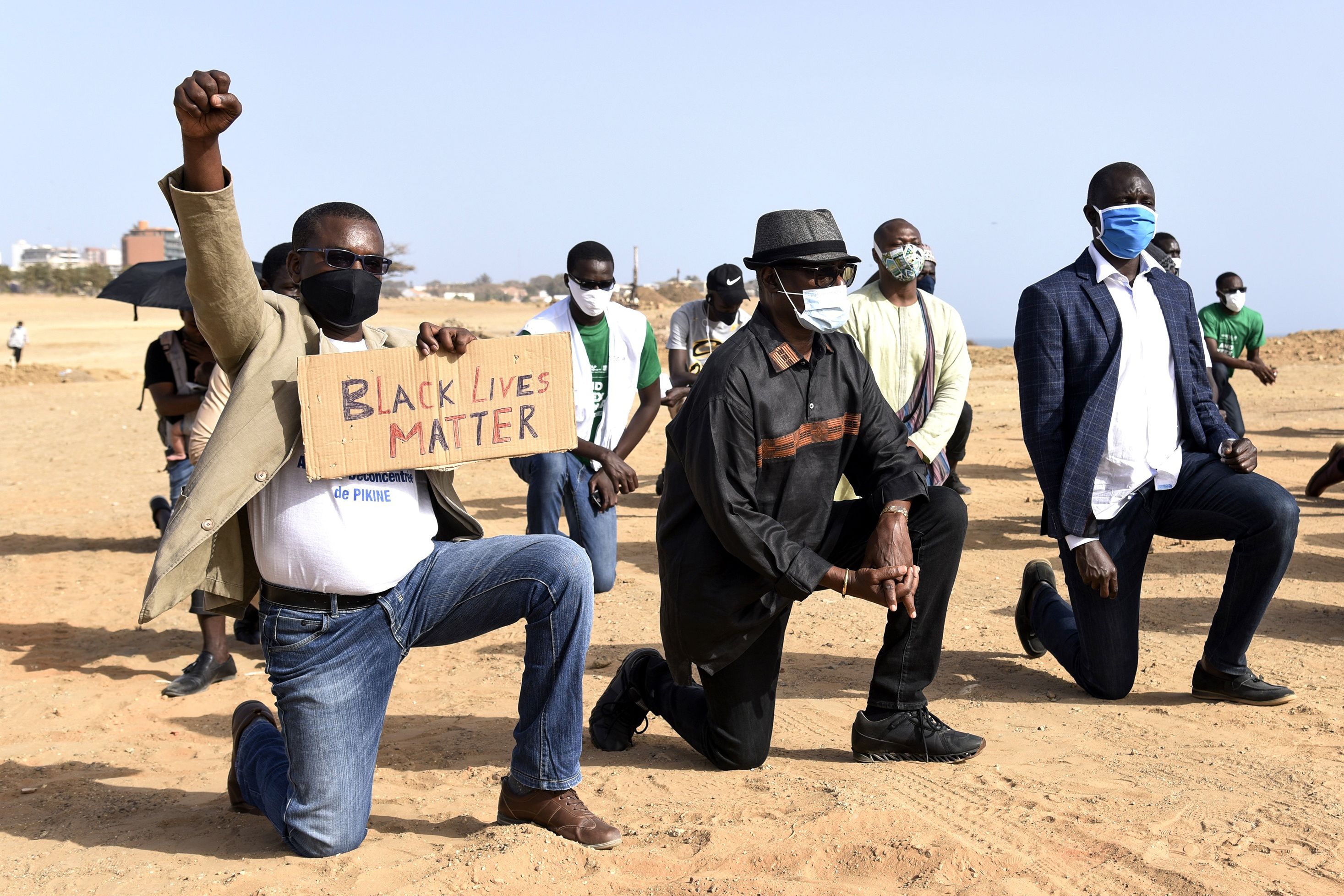 Protesters wearing face masks kneel in Dakar on June 9 during a rally in solidarity with the Black Lives Matter movement, and against racism and police brutality in the wake of the death of George Floyd.
