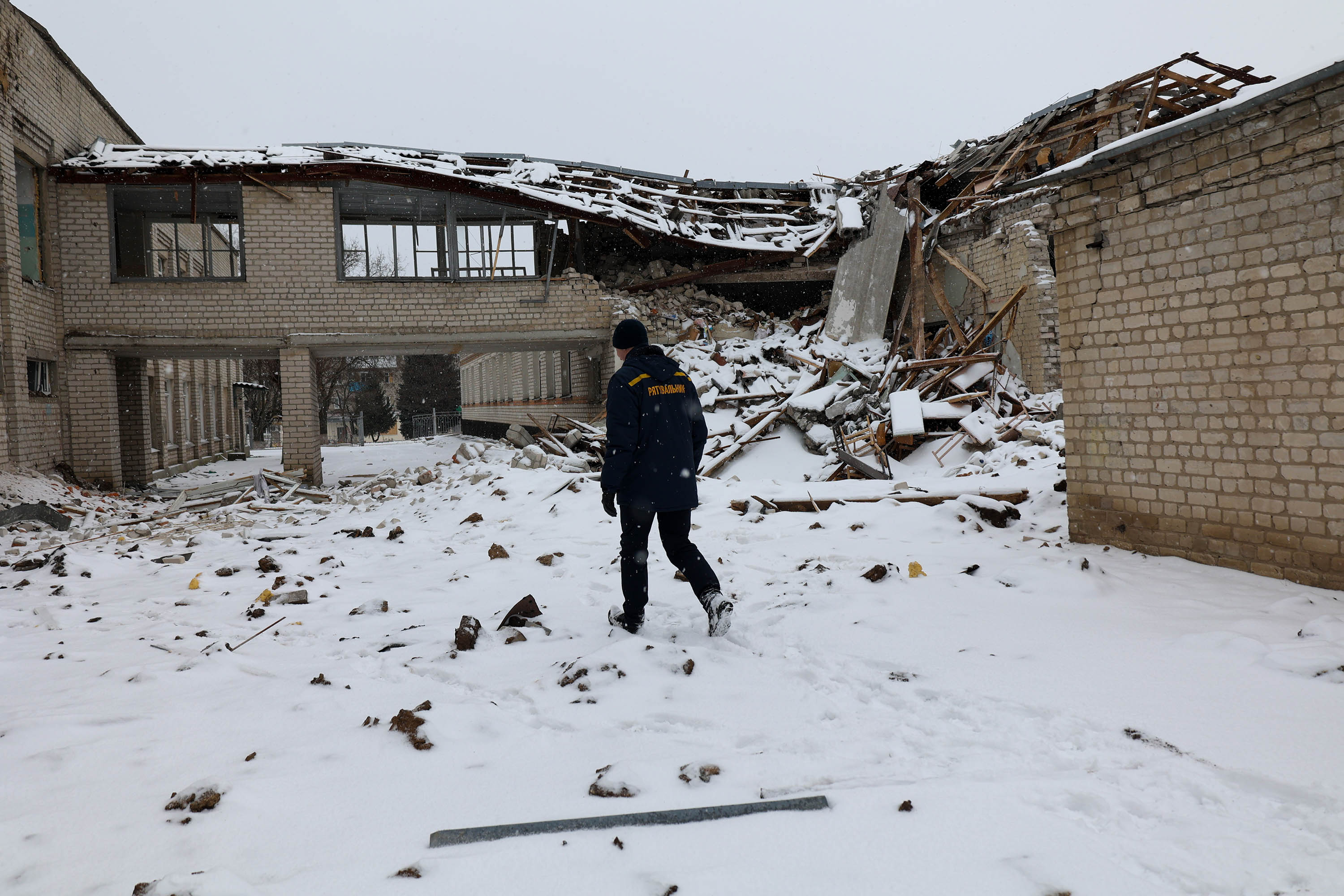 A Ukrainian rescuer walks through the remnants of a destroyed building in Kupyansk, Ukraine, on February 13 