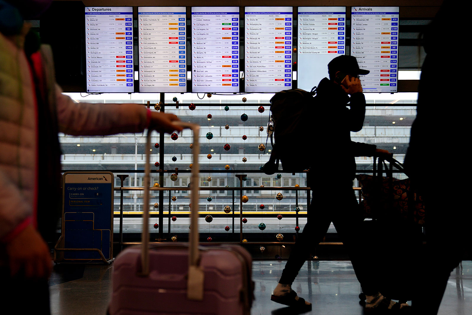 A traveler walks in front of a flight information screen at Chicago's O'Hare International Airport on Dec. 22.