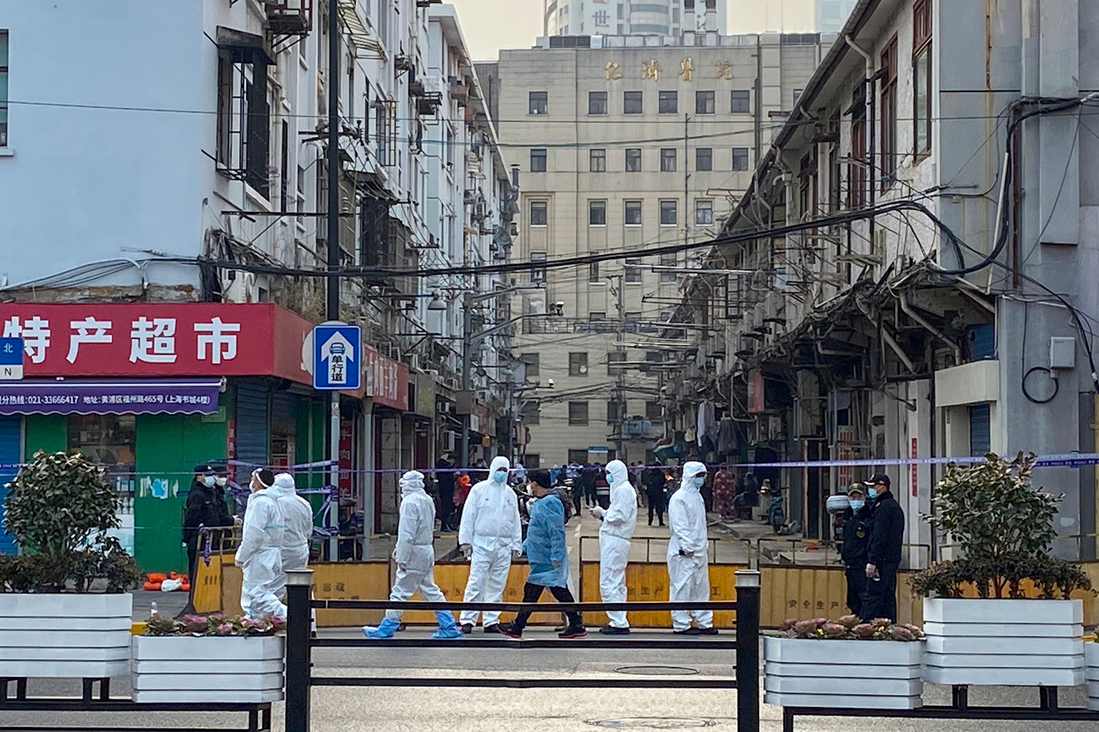 People in protective suits cordon off an area around a residential neighborhood in Shanghai's Huangpu district in China, on January 21.