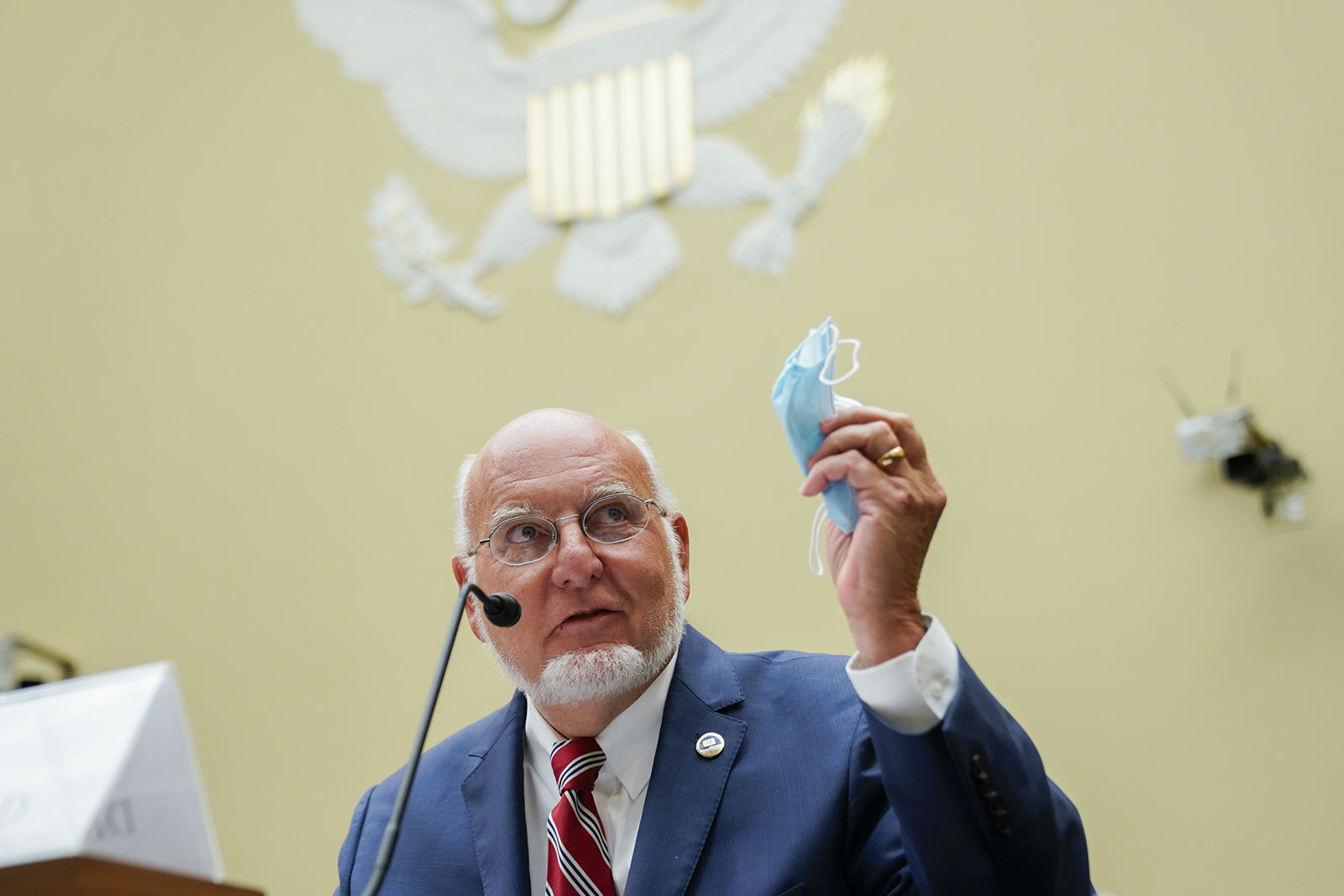 Robert Redfield, director of the Centers for Disease Control and Prevention holds a protective mask while testifying during a House Select Subcommittee on the Coronavirus Crisis hearing on July 31 in Washington.