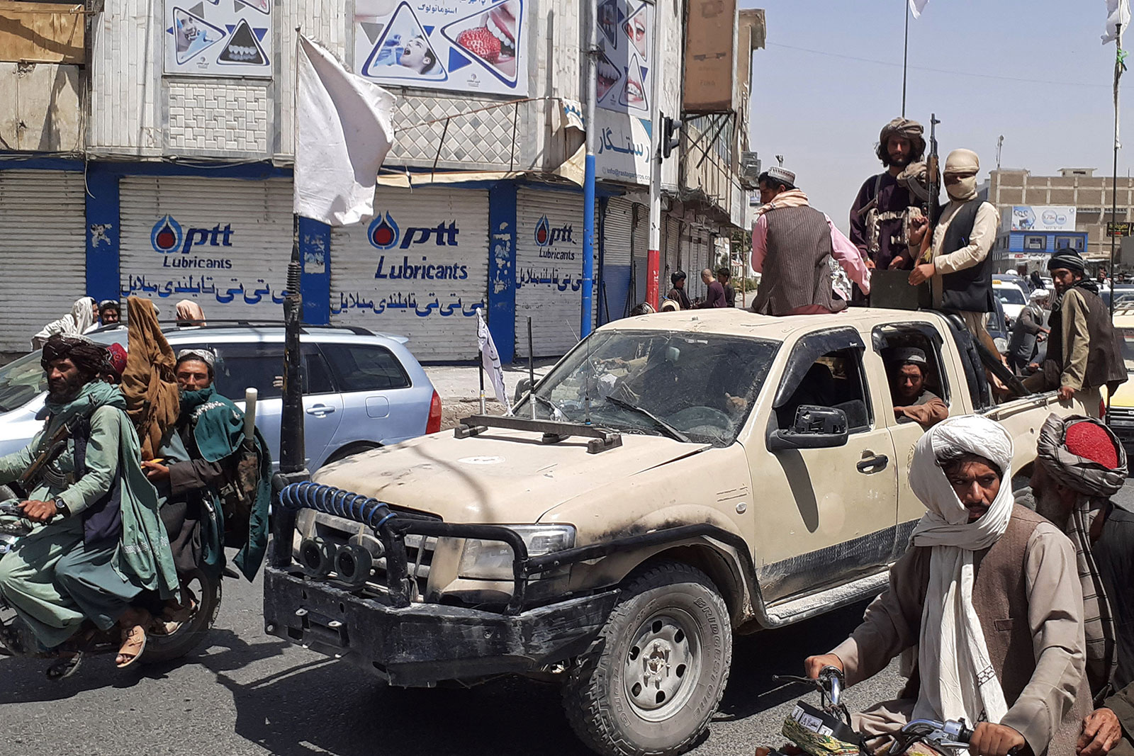 Taliban fighters drive an Afghan National Army vehicle through a street in Kandahar on August 13.