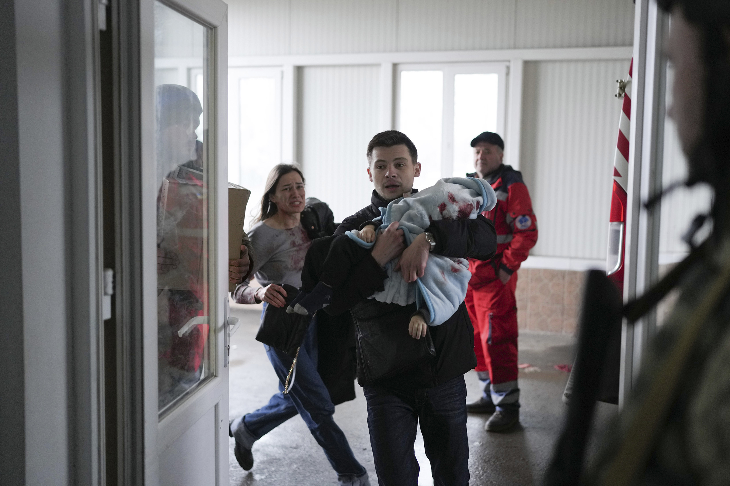 Marina Yatsko, left, runs behind her boyfriend Fedor as they arrive at the hospital with Kirill.