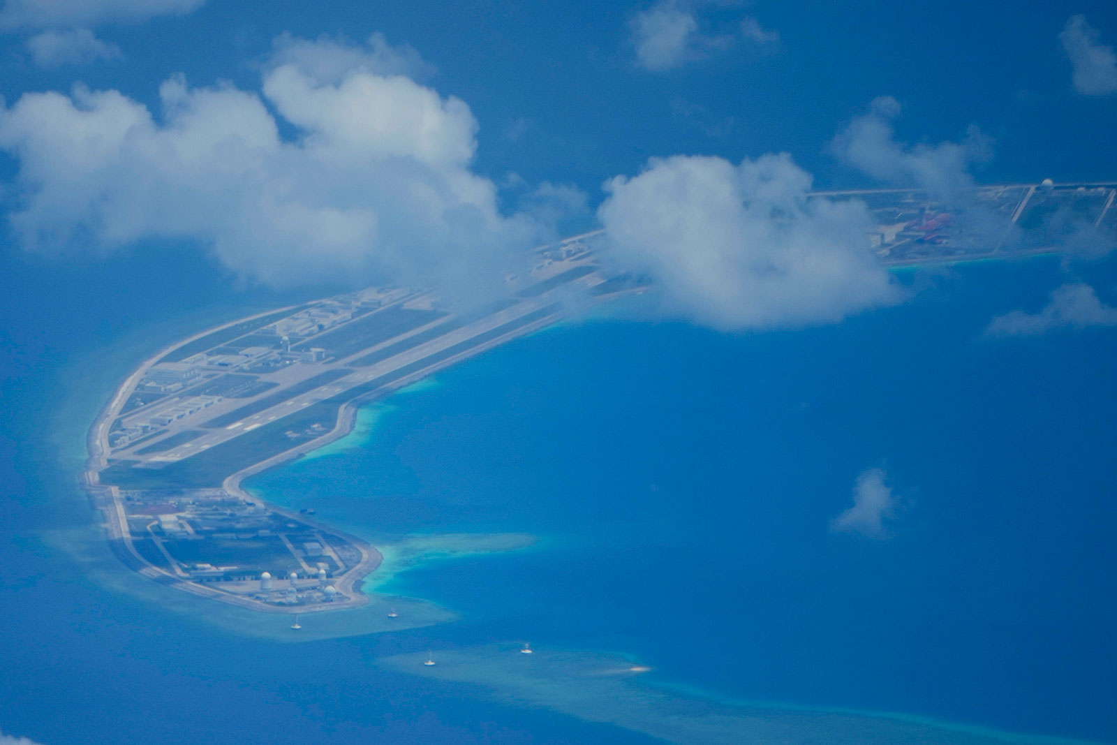 A Chinese air strip is visible beside structures and buildings on Mischief Reef in the Spratly group of islands in the South China Sea, March 20, 2022.