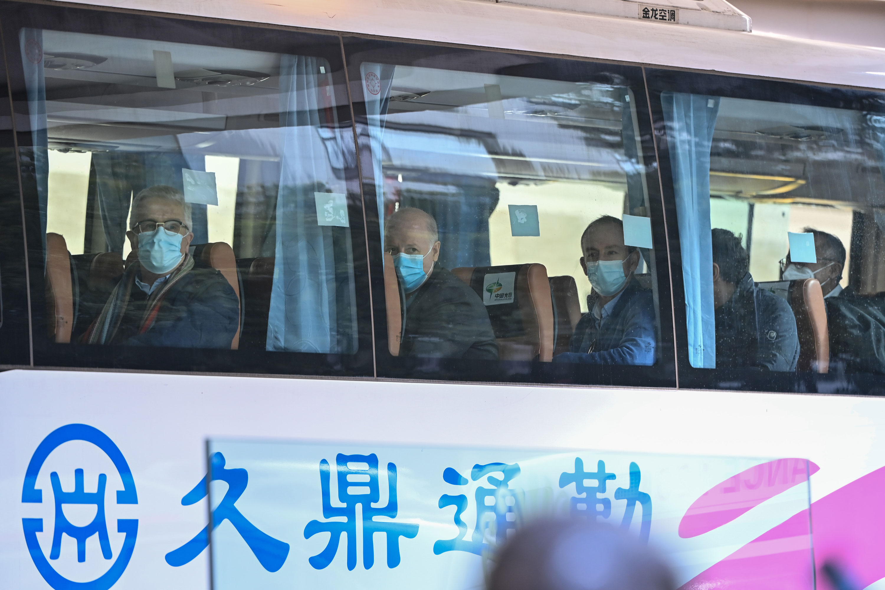 Members of the World Health Organization team investigating the origins of the Covid-19 coronavirus pandemic leave The Jade Hotel on a bus after completing their quarantine in Wuhan, China on January 28.