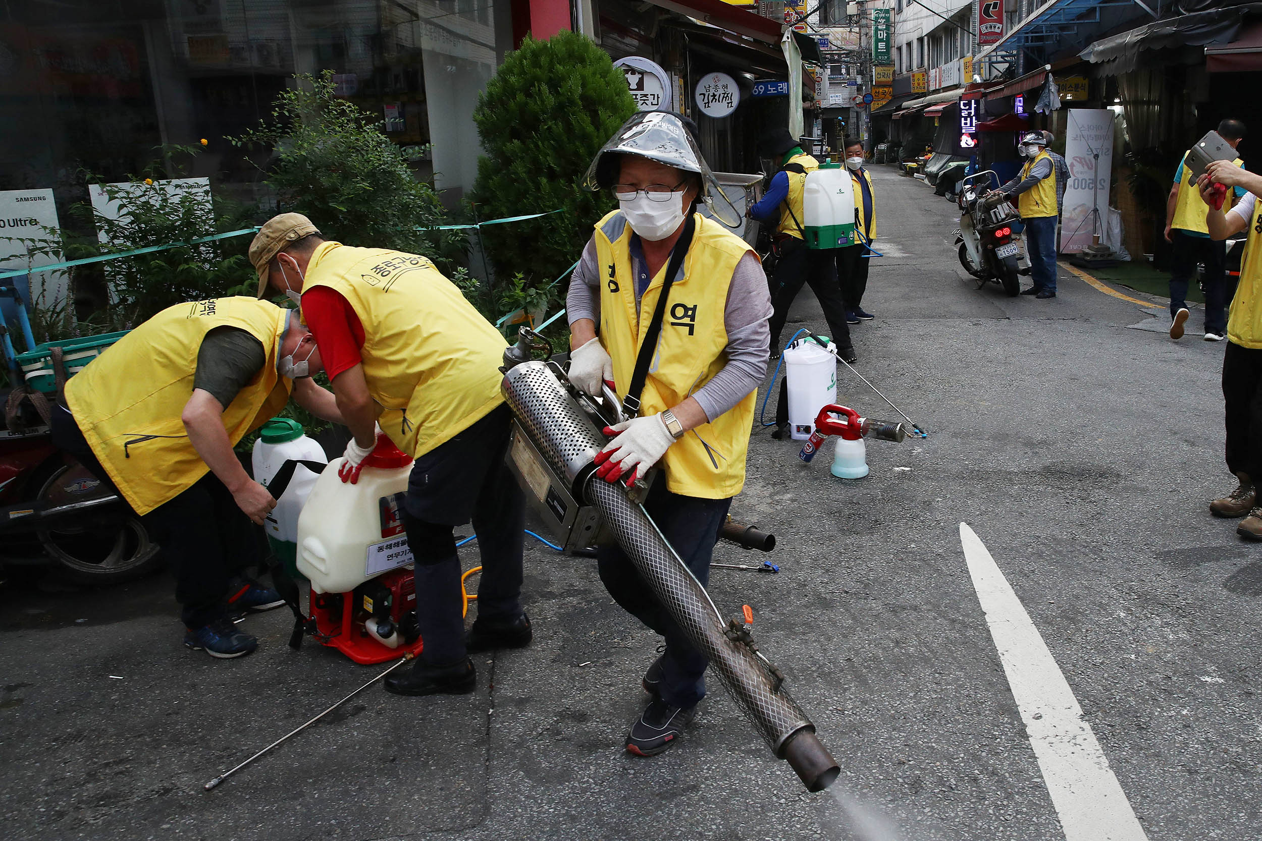 Workers get ready to disinfect an alley to prevent the coronavirus spread on August 29, in Seoul, South Korea. 