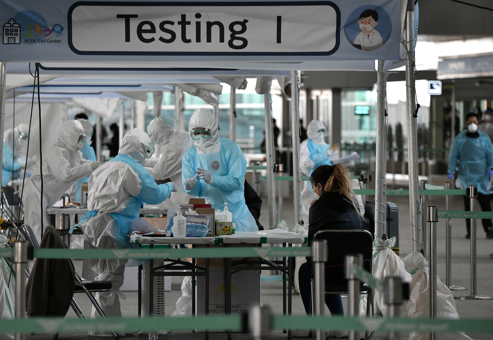 Medical staff swab samples for the coronavirus from a foreign passenger at a virus testing booth outside Incheon international airport in Seoul, Korea on April 1. 