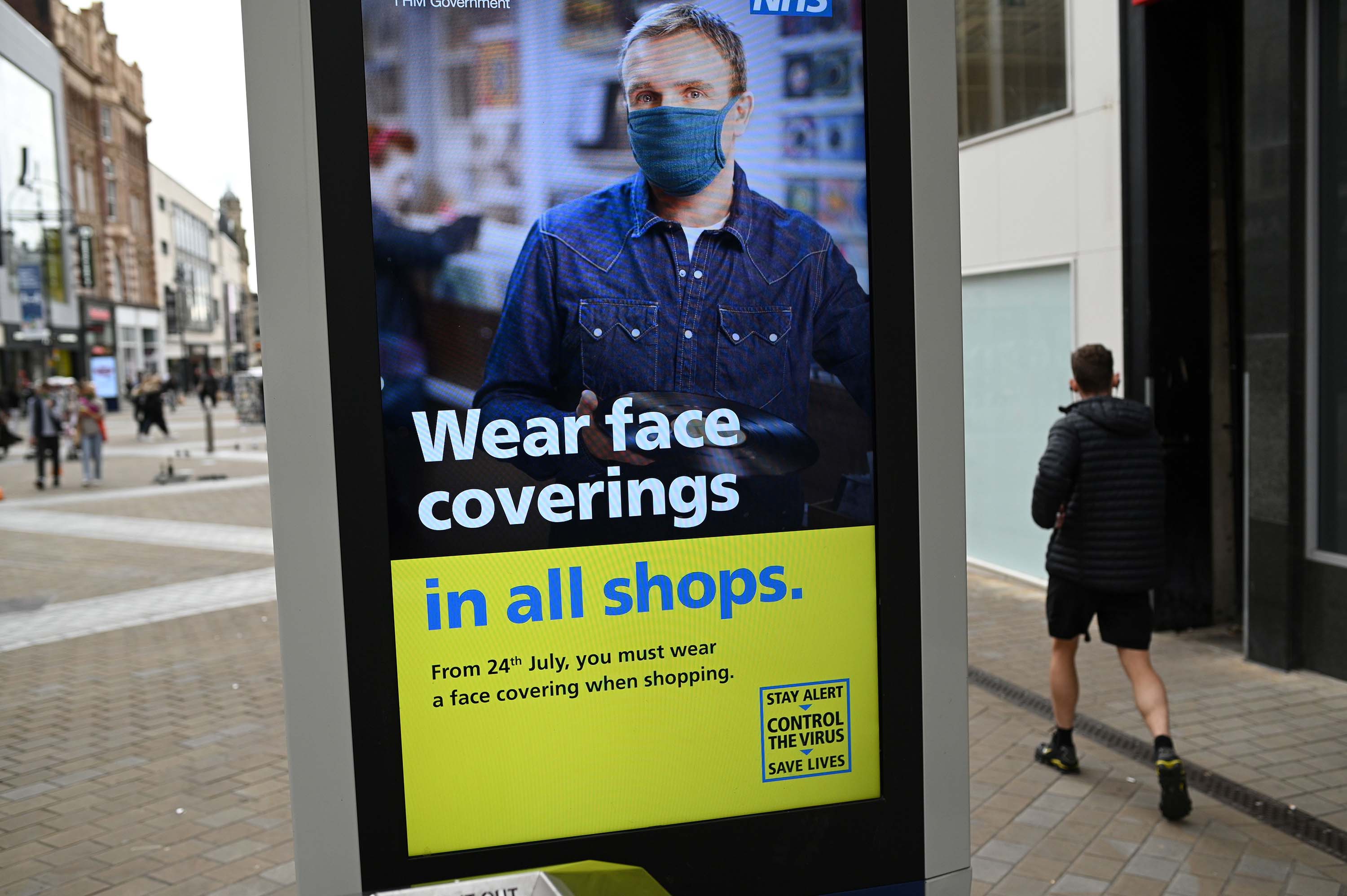 A sign calling for the wearing of face coverings in shops is displayed in Leeds, England, on July 23.