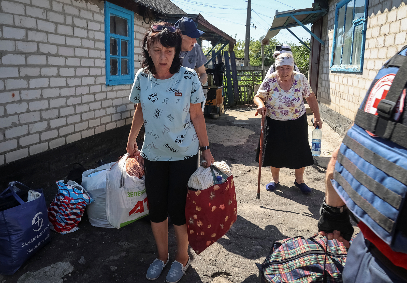 Local residents evacuate as a Red Cross volunteer helps them in the city of Kupiansk-Vuzlovyi in Kharkiv region, Ukraine on August 15.