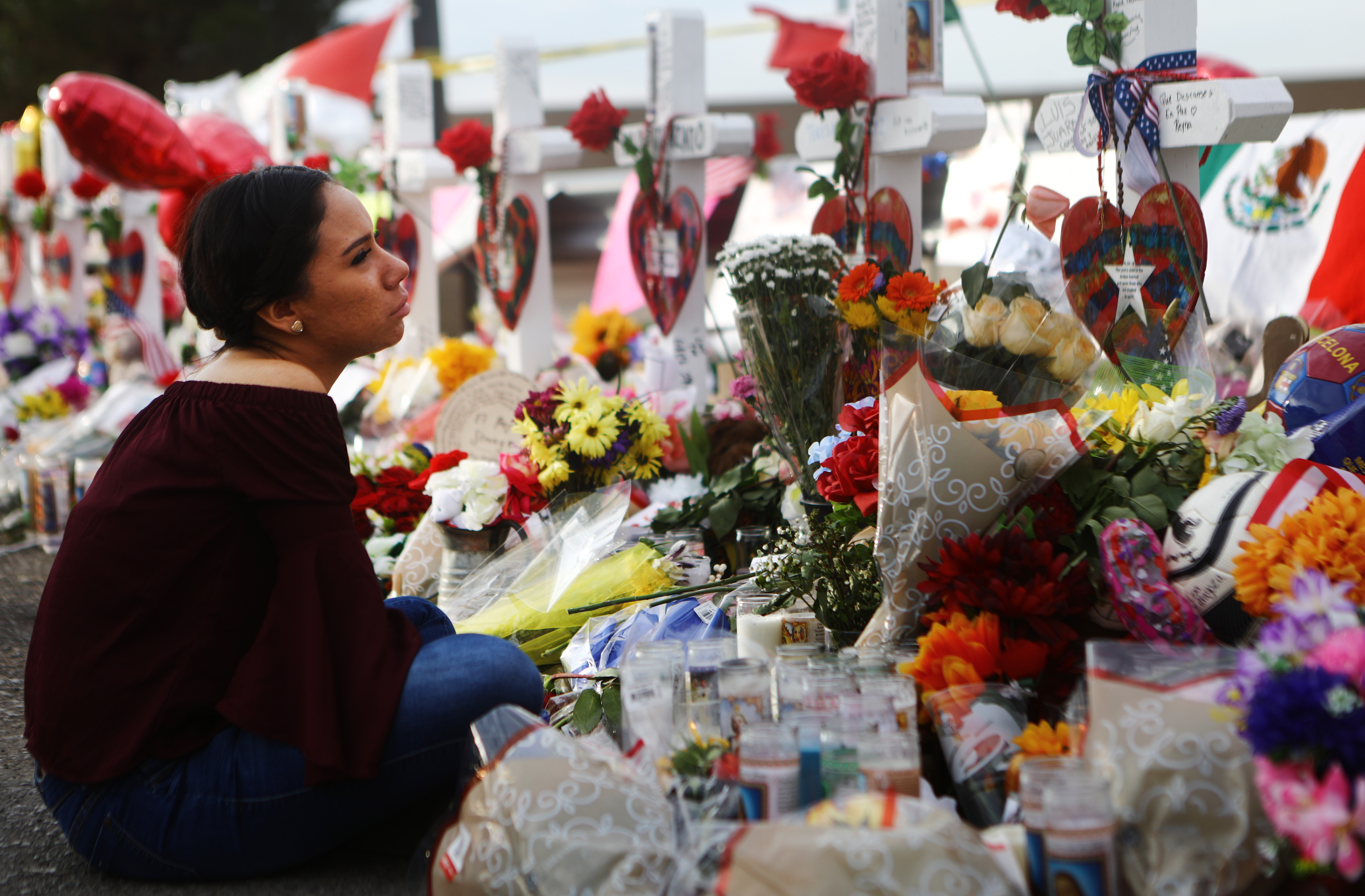 Yamileth Lopez sits while holding a photo of her deceased friend Javier Amir Rodriguez at a makeshift memorial for victims outside Walmart on Aug. 6, 2019 in El Paso, Texas. 