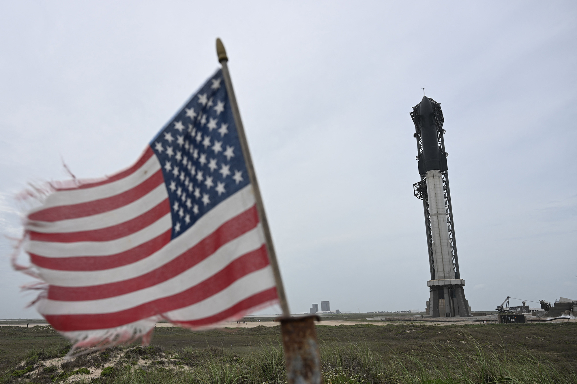 An American flag waves in the wind as the SpaceX Starship stands on the launch pad ahead of the flight test on Sunday, April 16.