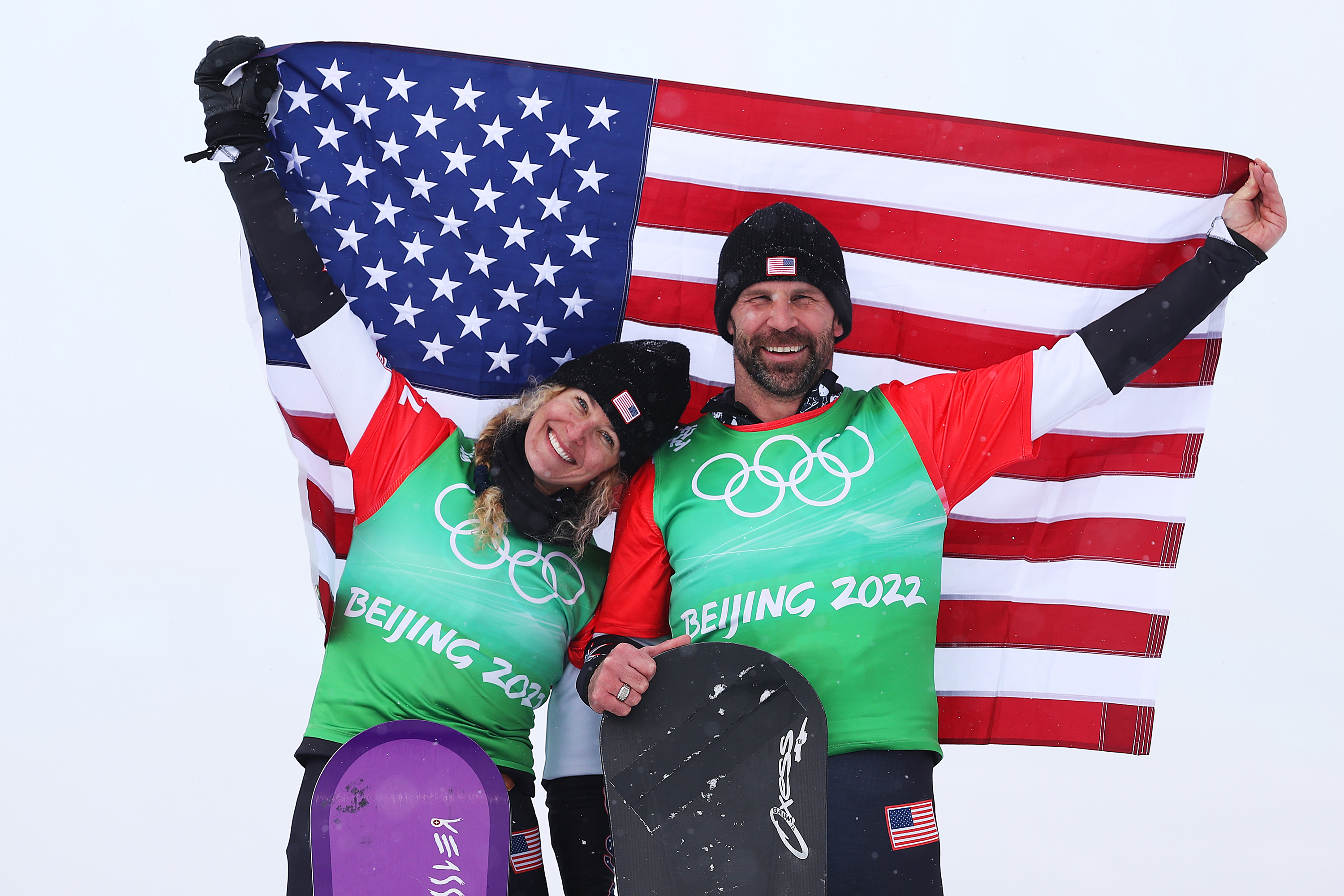 Team USA's Lindsey Jacobellis and Nick Baumgartner celebrate during the mixed team snowboard cross final flower ceremony on Feb. 12.
