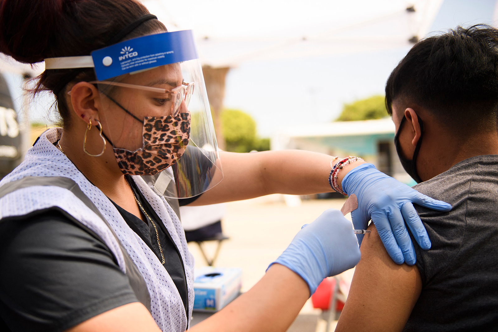 A 17-year-old receives a first dose of the Pfizer Covid-19 vaccine at a mobile vaccination clinic during a back to school event offering school supplies, Covid-19 vaccinations, face masks, and other resources for children and their families at the Weingart East Los Angeles YMCA.