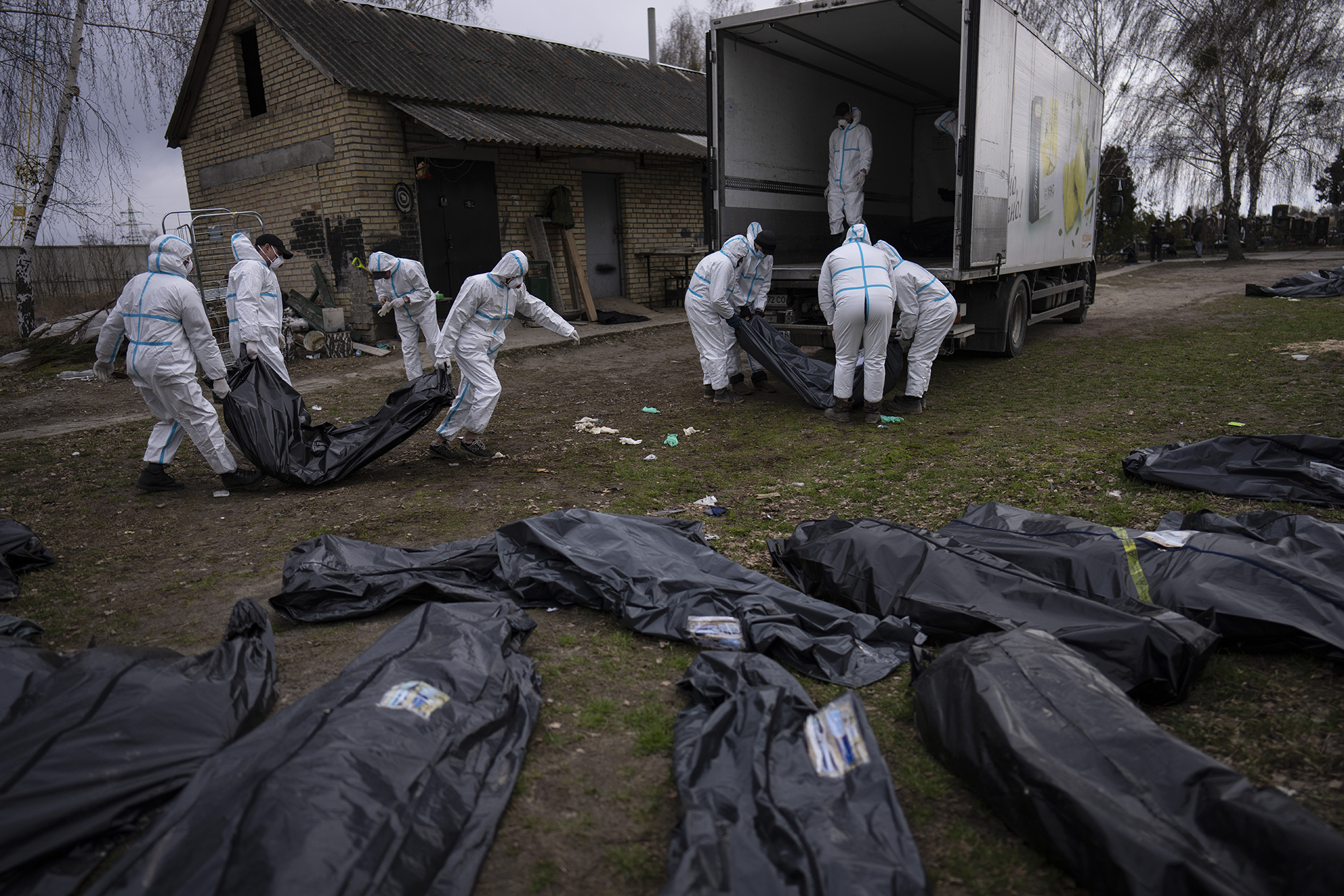 Volunteers load bodies of civilians killed in Bucha onto a truck to be taken to a morgue for investigation, in Bucha, Ukraine, on April 12 2022.