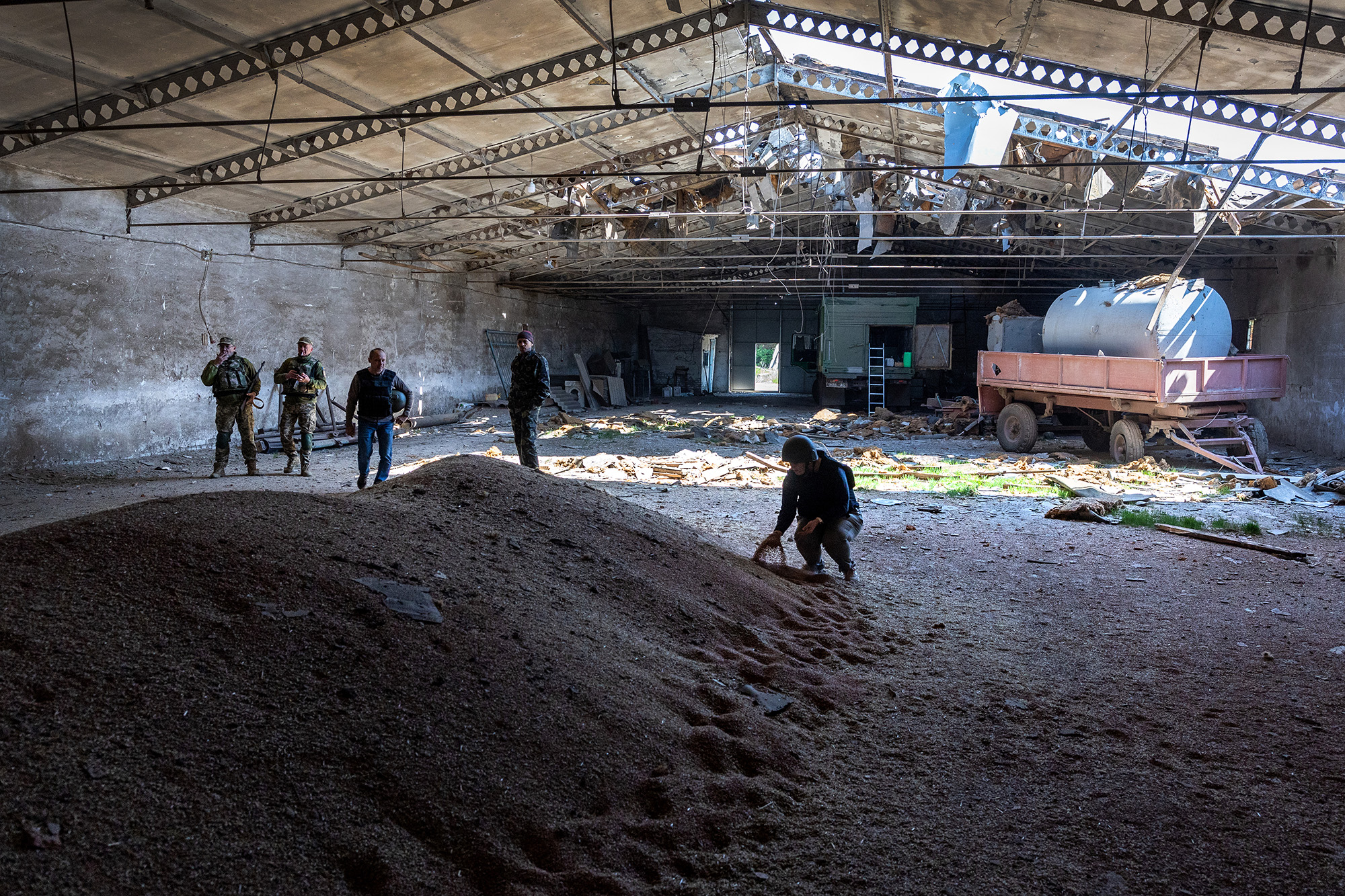 Local government officials and Ukrainian soldiers inspect a wheat grain warehouse earlier shelled by Russian forces on May 6, near the frontlines of Kherson in Novovorontsovka, Ukraine. 
