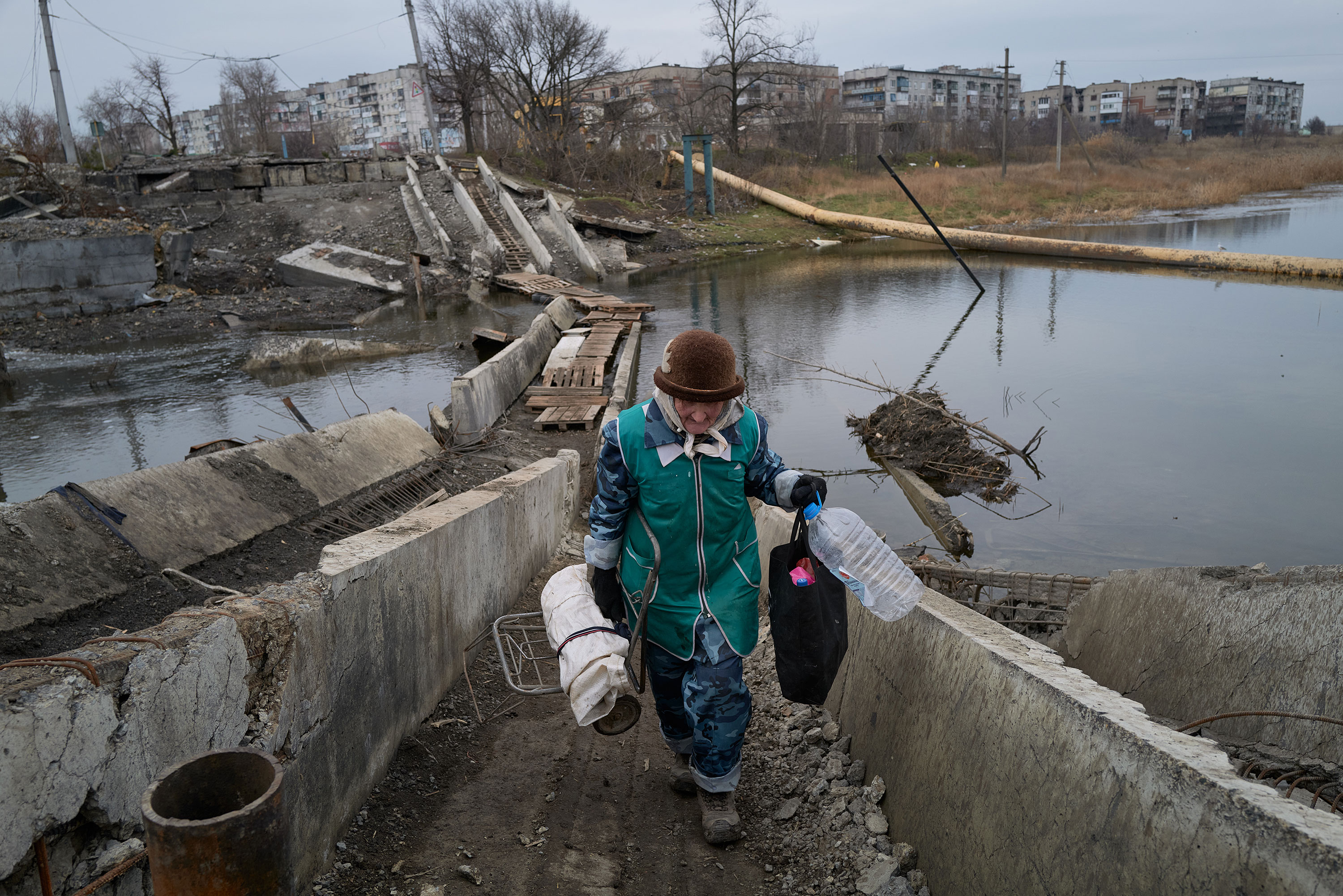 A woman crosses a destroyed bridge amid artillery shelling in Bakhmut on Saturday.