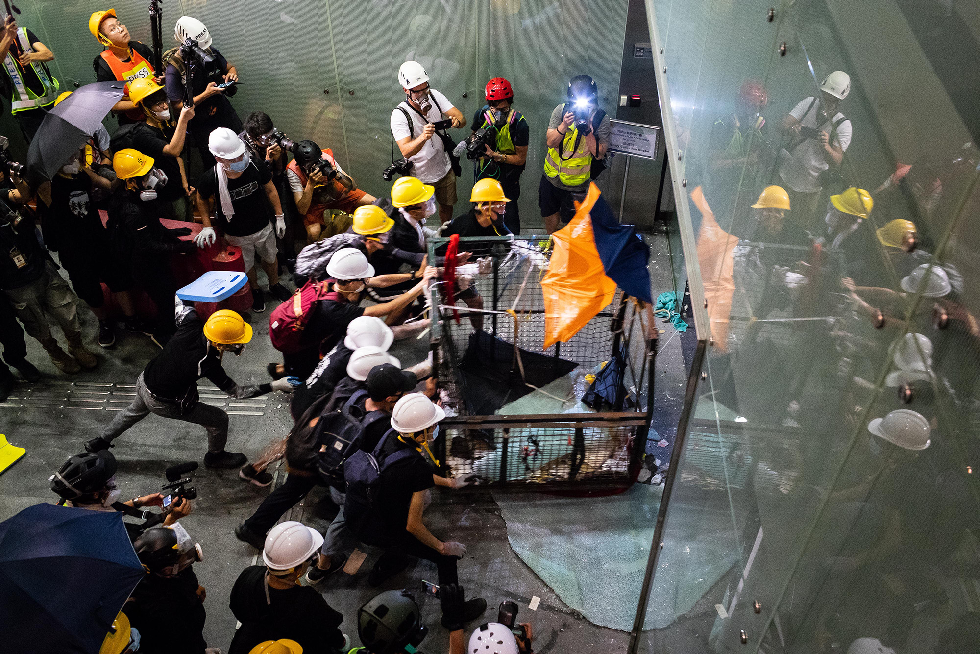 Demonstrators push a metal cart into a window into the Legislative Council building during a protest in Hong Kong, on Monday, July 1, 2019. 
