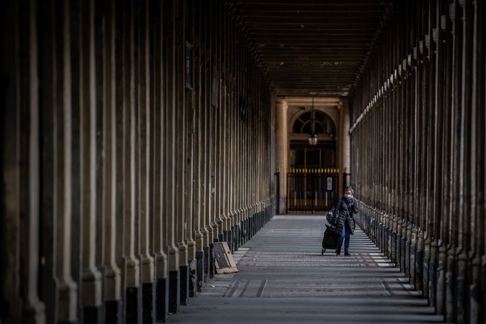 A woman wearing a facemask walks along the Jardin du Palais Royal on May 2 in Paris.