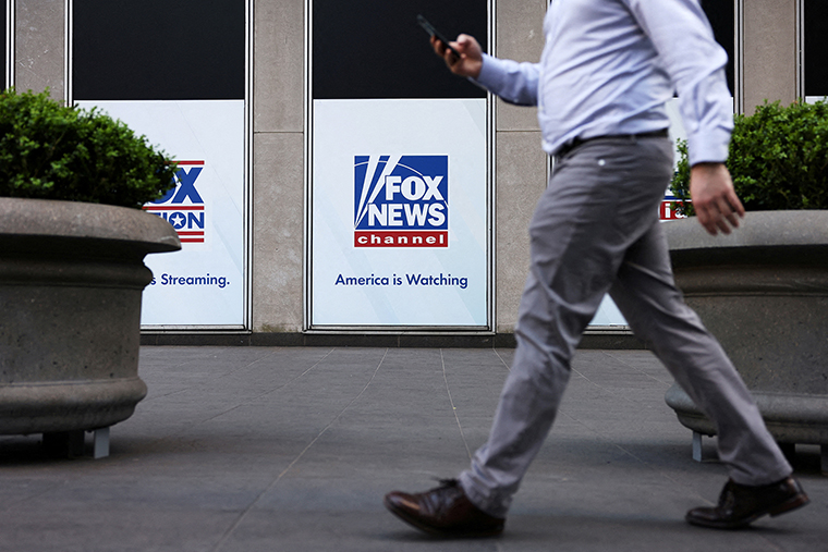 A person walks by Fox News signage posted on the News Corporation building in New York City on April 12. 