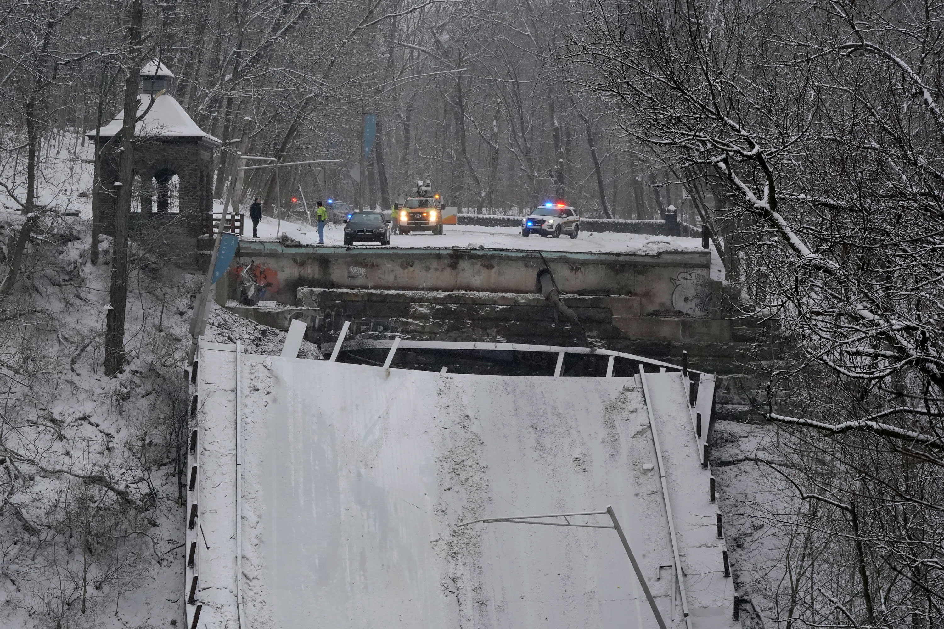 Emergency personnel are seen at the edge of the bridge that collapsed in Pittsburgh on Friday.