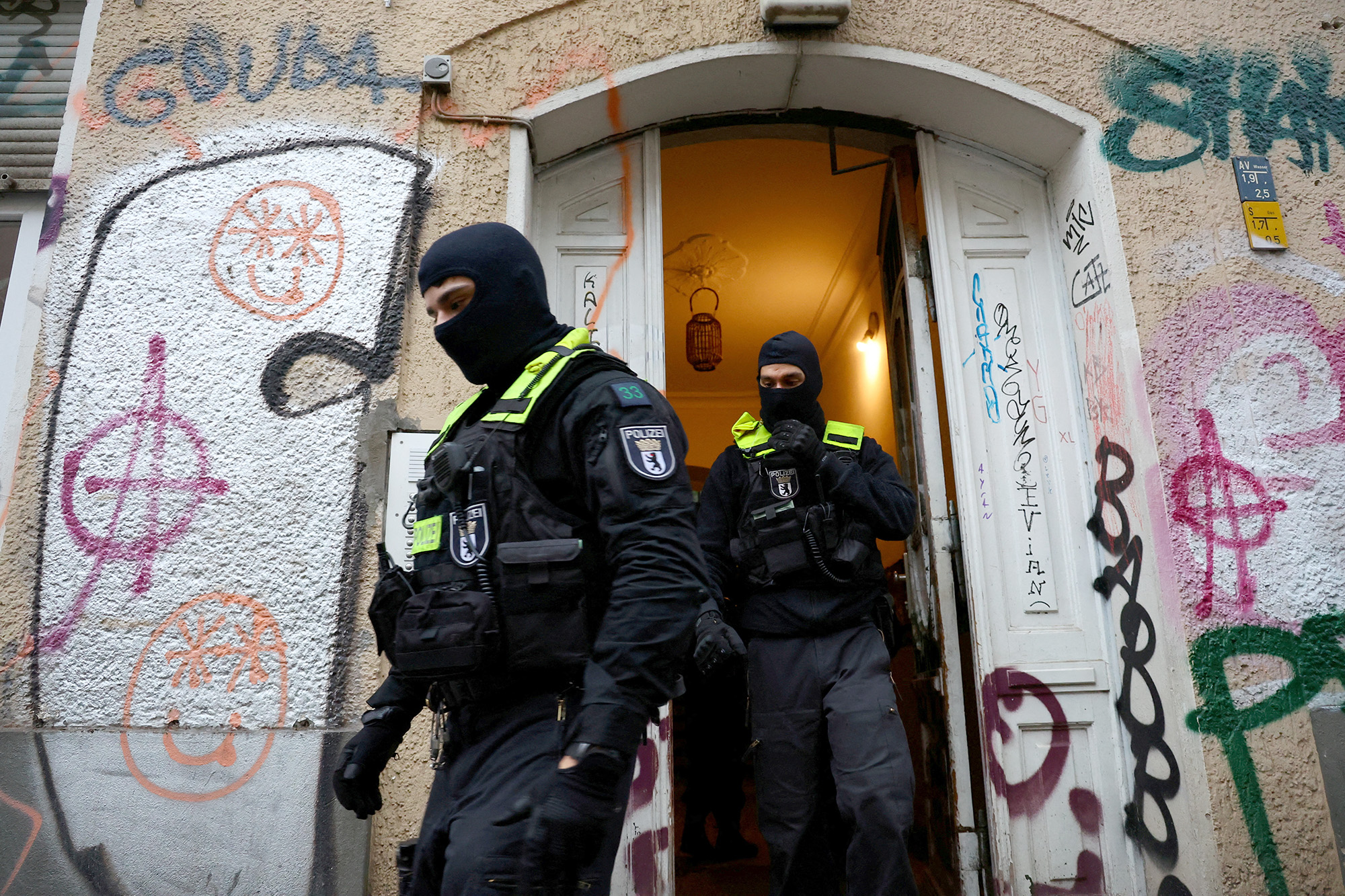 German police officers leave a house during a raid against people supporting Hamas, in Berlin, Germany, on November 23.