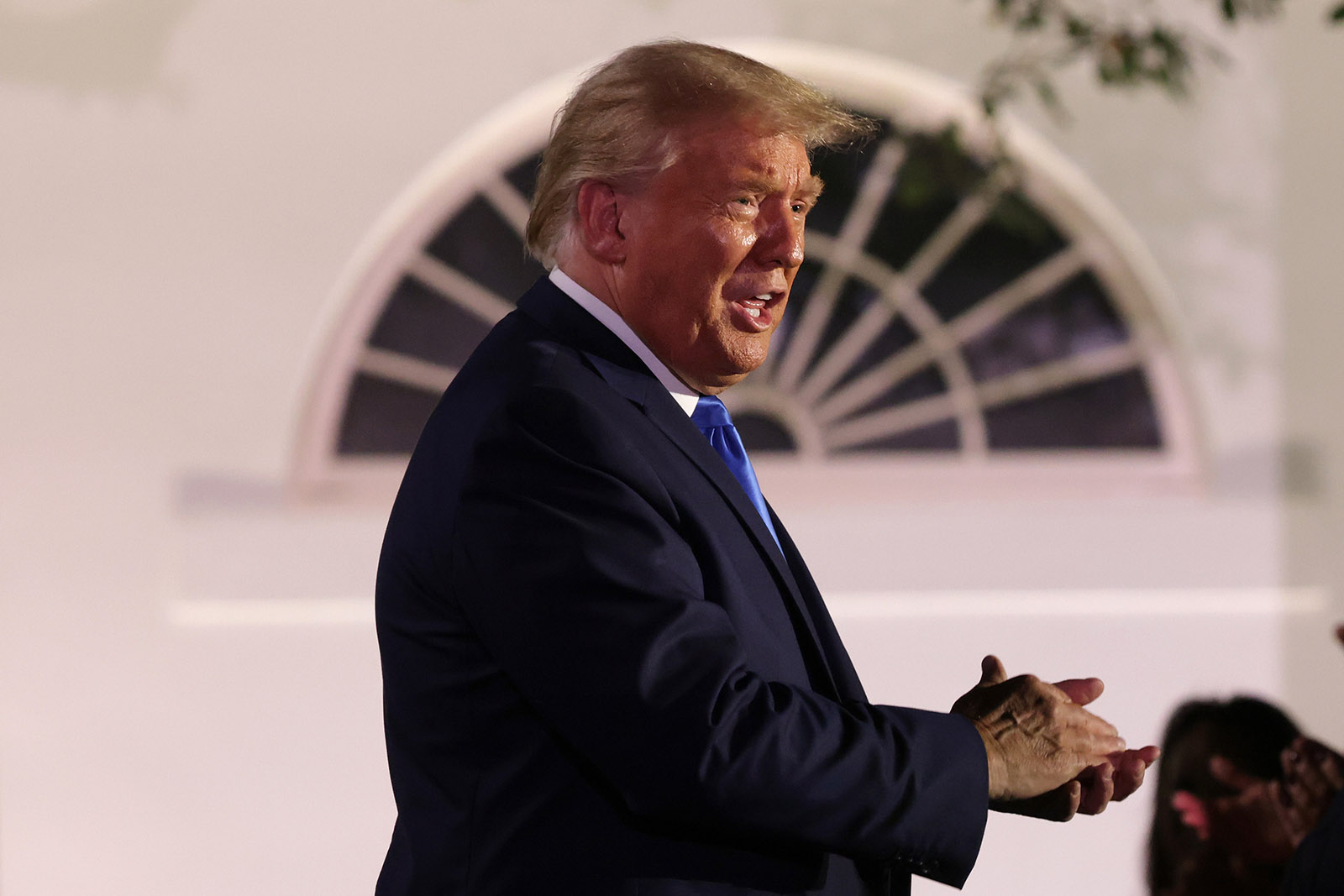 President Donald Trump applauds as he arrives to listen to first lady Melania Trump's address to the Republican National Convention from the Rose Garden at the White House on August 25 in Washington.