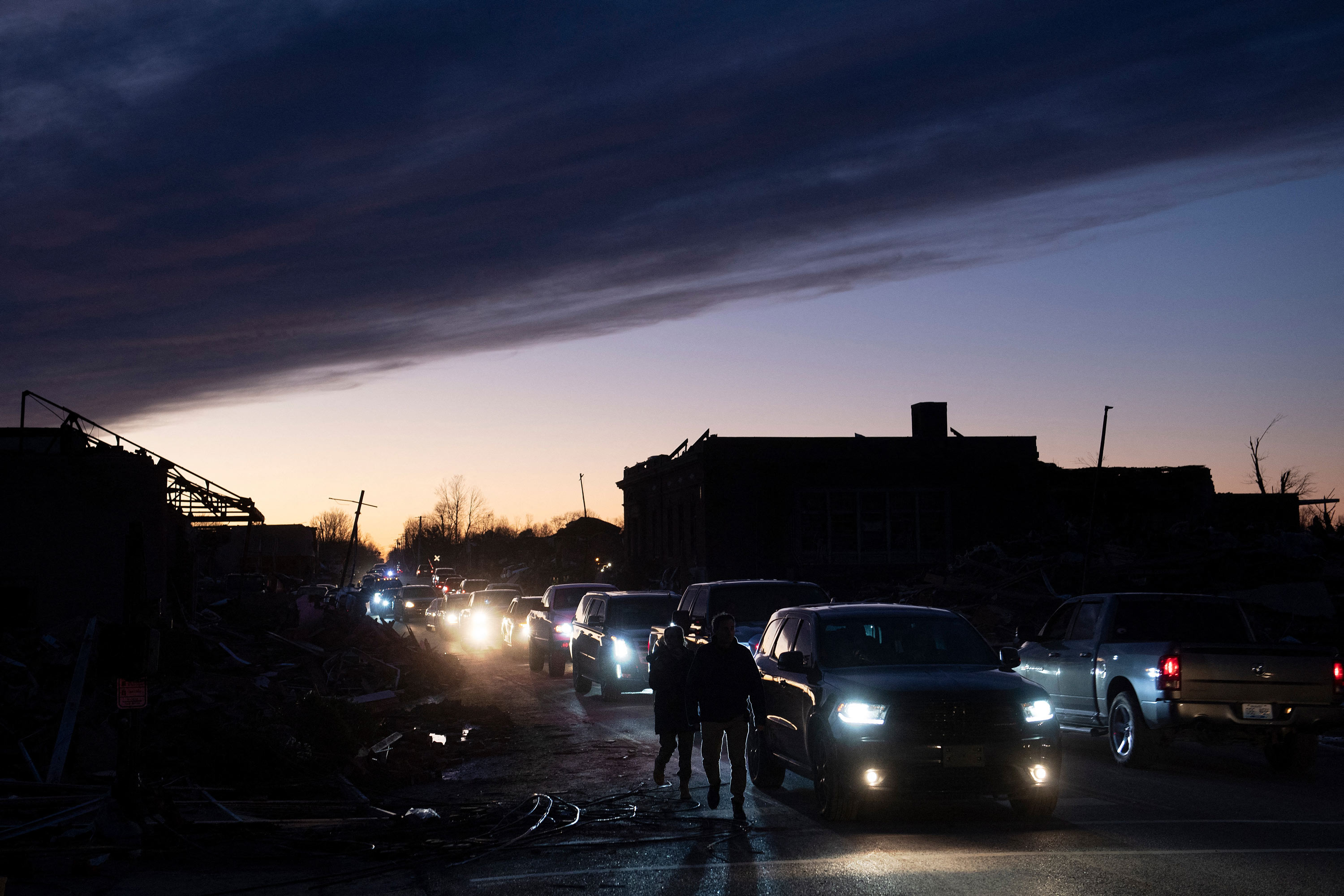 Cars make their way past tornado damage on December 11, in Mayfield, Kentucky. 