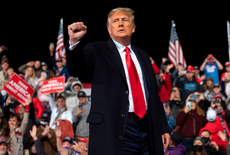 US President Donald Trump holds up his fist as he leaves the stage at the end of a rally to support Republican Senate candidates at Valdosta Regional Airport in Valdosta, Georgia on Saturday, December 5. 