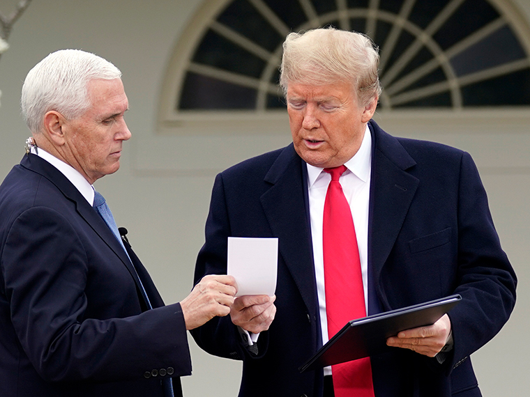 President Donald Trump speaks with Vice President Mike Pence as they arrive for a Fox News Channel virtual town hall, at the White House, Tuesday, March 24. 