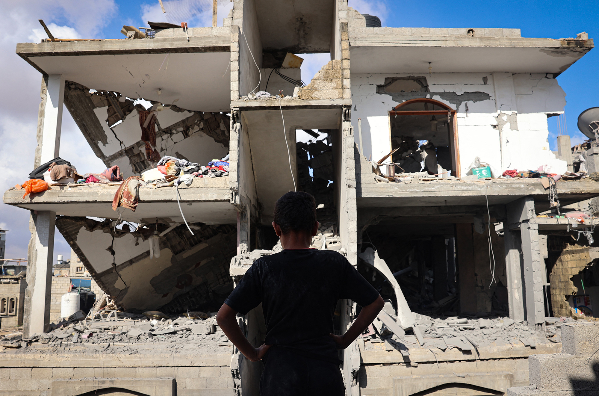 A Palestinian boy stands in front of a destroyed building following Israeli bombardment of Rafah's Tal al-Sultan district in the southern Gaza, on May 7. 