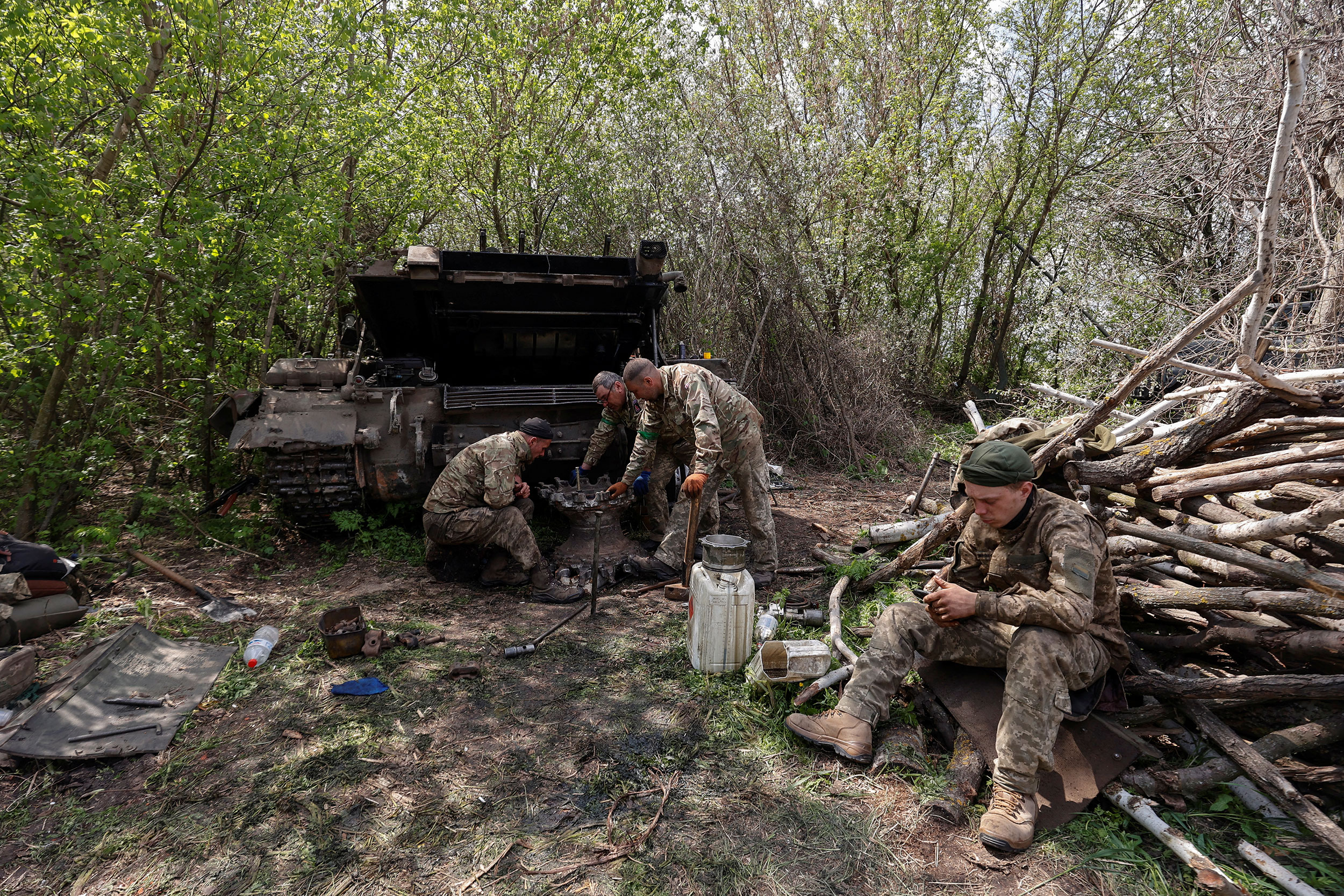 Ukrainian soldiers repair a tank at a position near Kharkiv, Ukraine, on May 1.