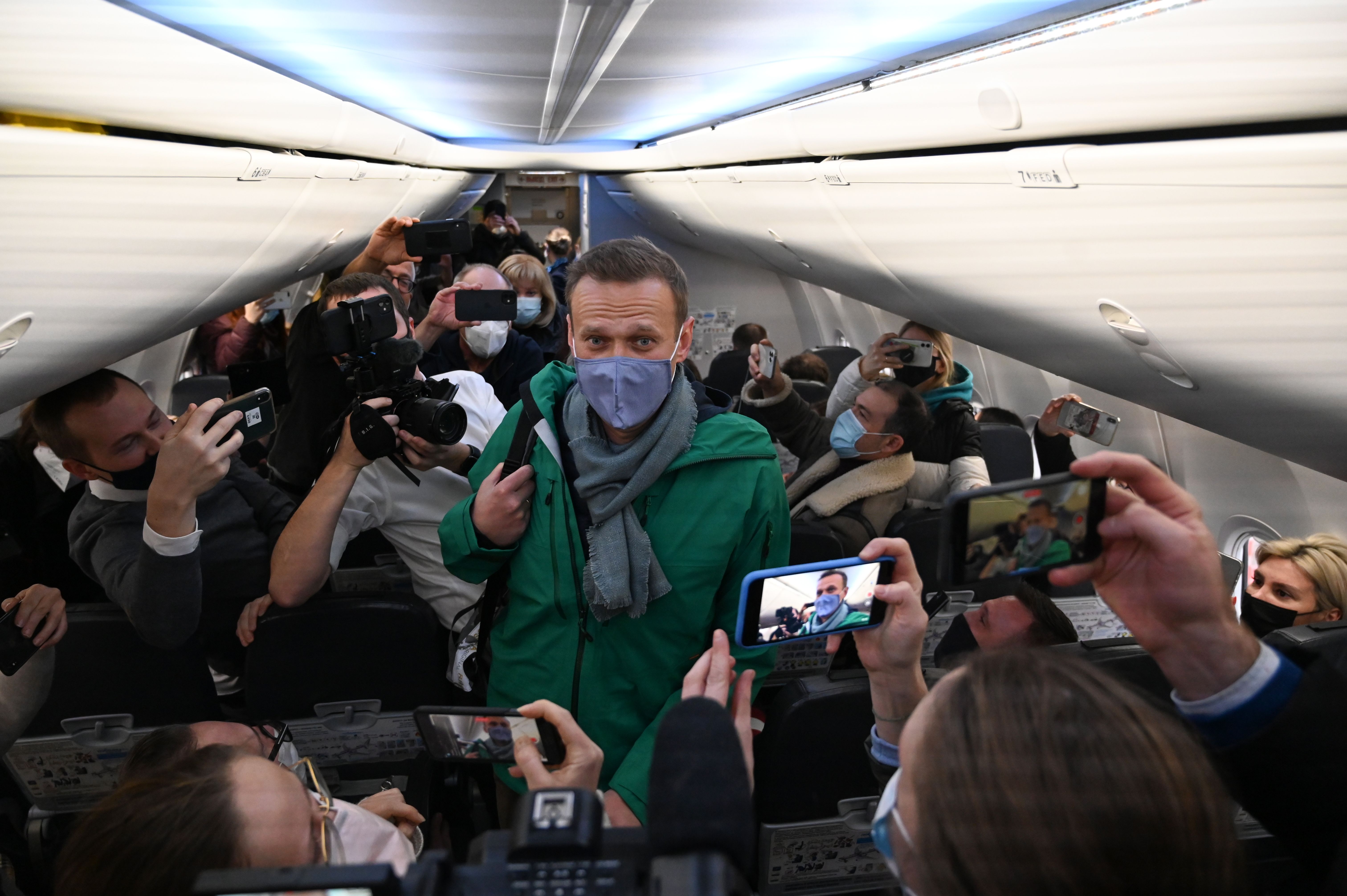 Navalny takes his seat on a Moscow-bound plane before taking off from Berlin in January 2021. Navalny was detained by police moments after landing in Russia.