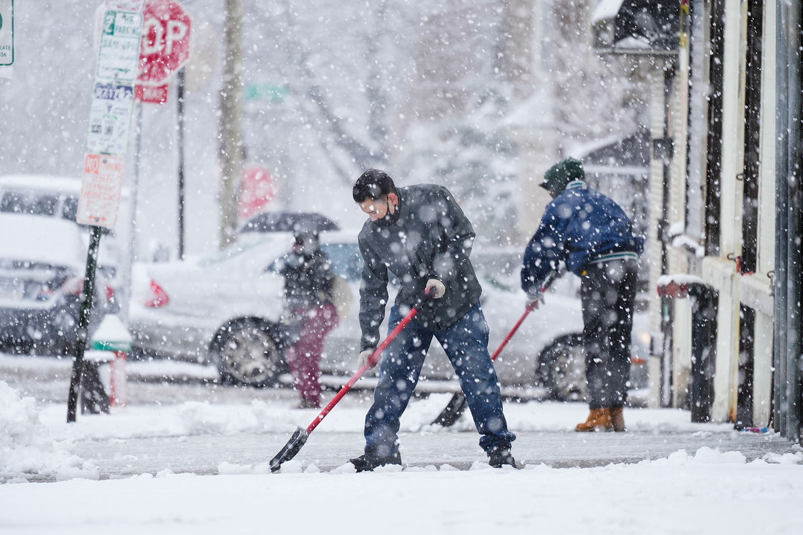People clear a sidewalk during a winter snow storm in Philadelphia on Tuesday.