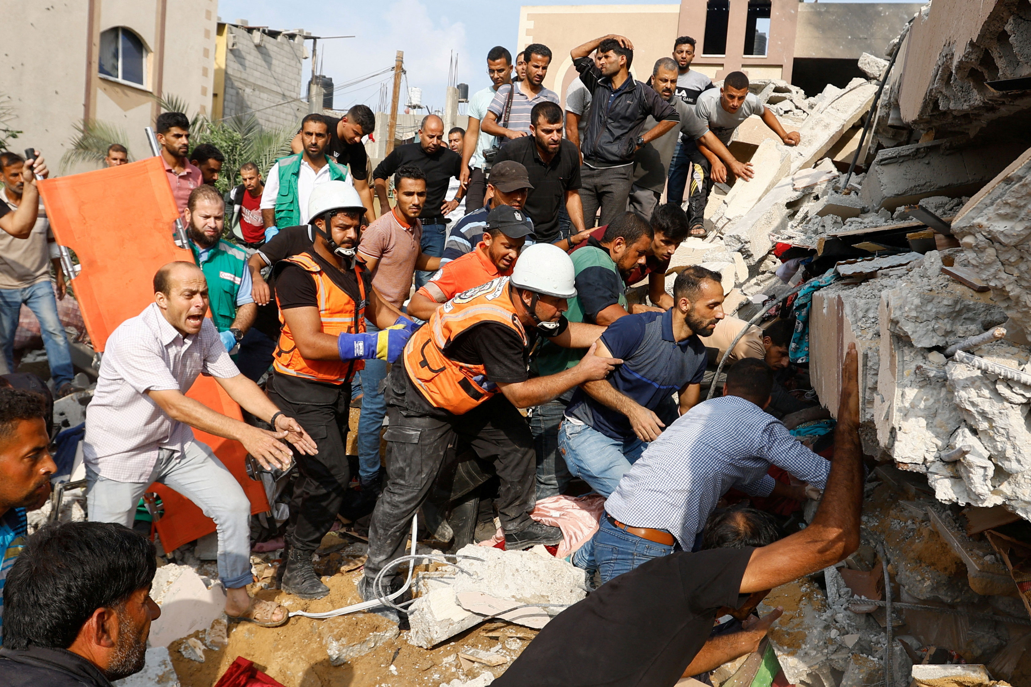 Palestinians search for casualties under the rubble of a house destroyed in Israeli strikes in Khan Younis, in the southern Gaza Strip, on October 8, 2023.