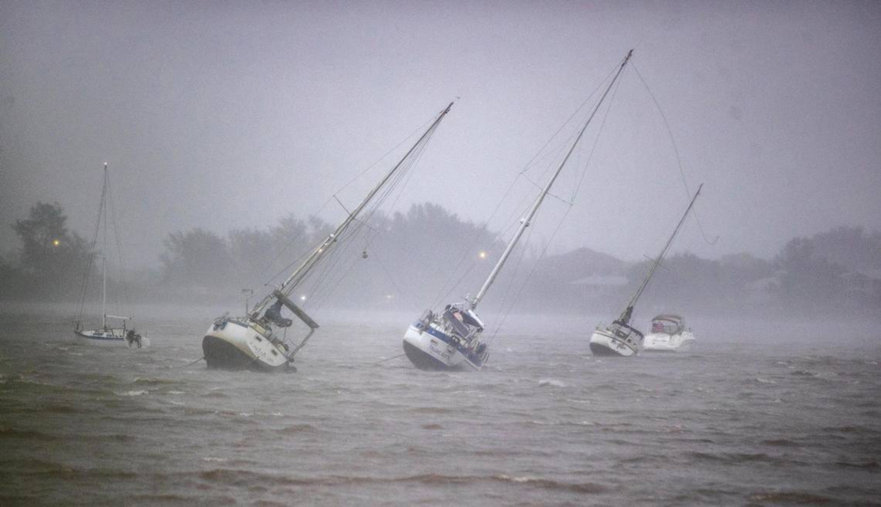 Sail boats anchored in Roberts Bay are blown around by winds in Venice, Florida, on Wednesday.