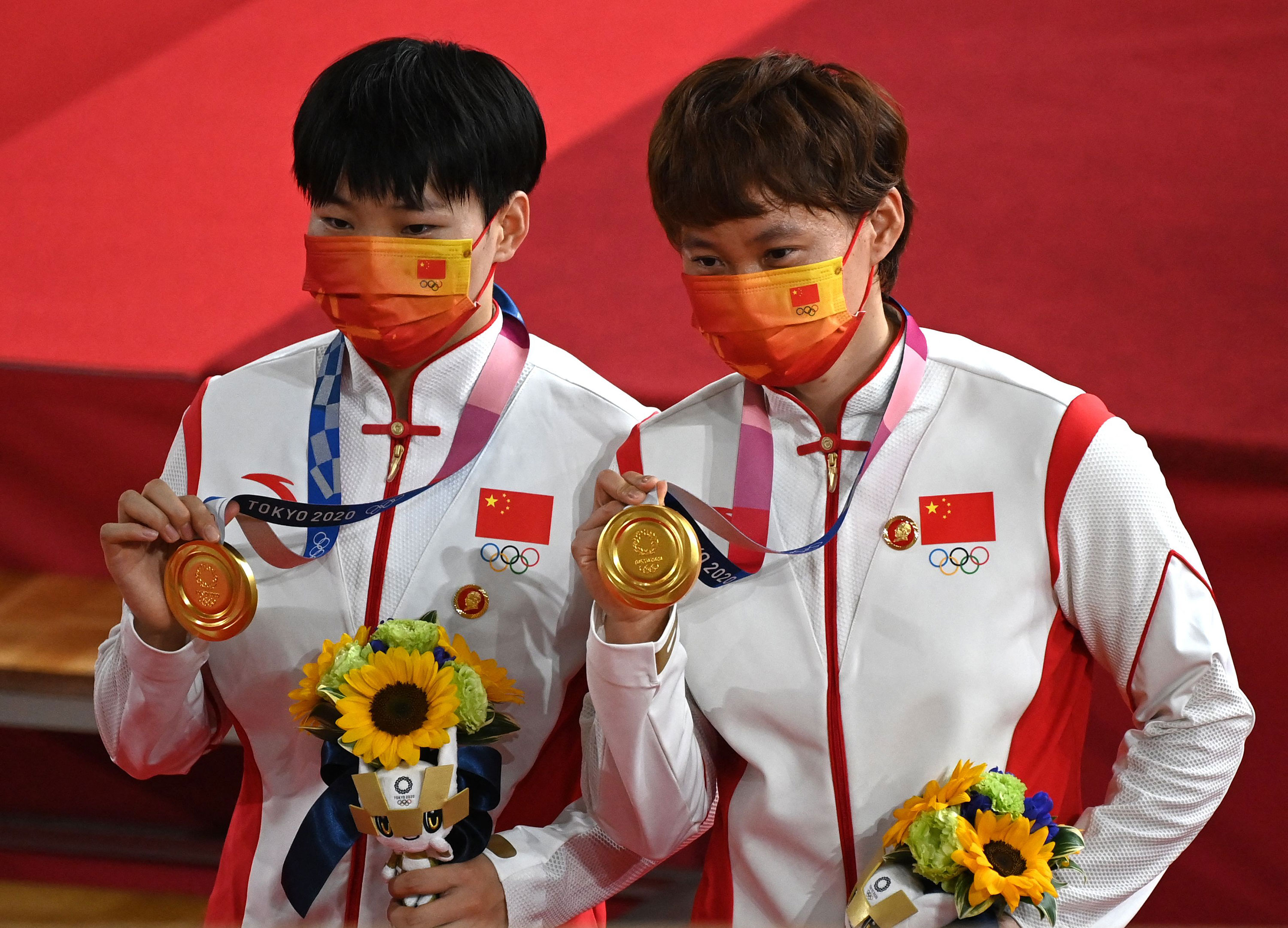 China's Bao Shanju, left, and Zhong Tianshi pose with their gold medals on the podium after the track cycling team sprint final on August 2.