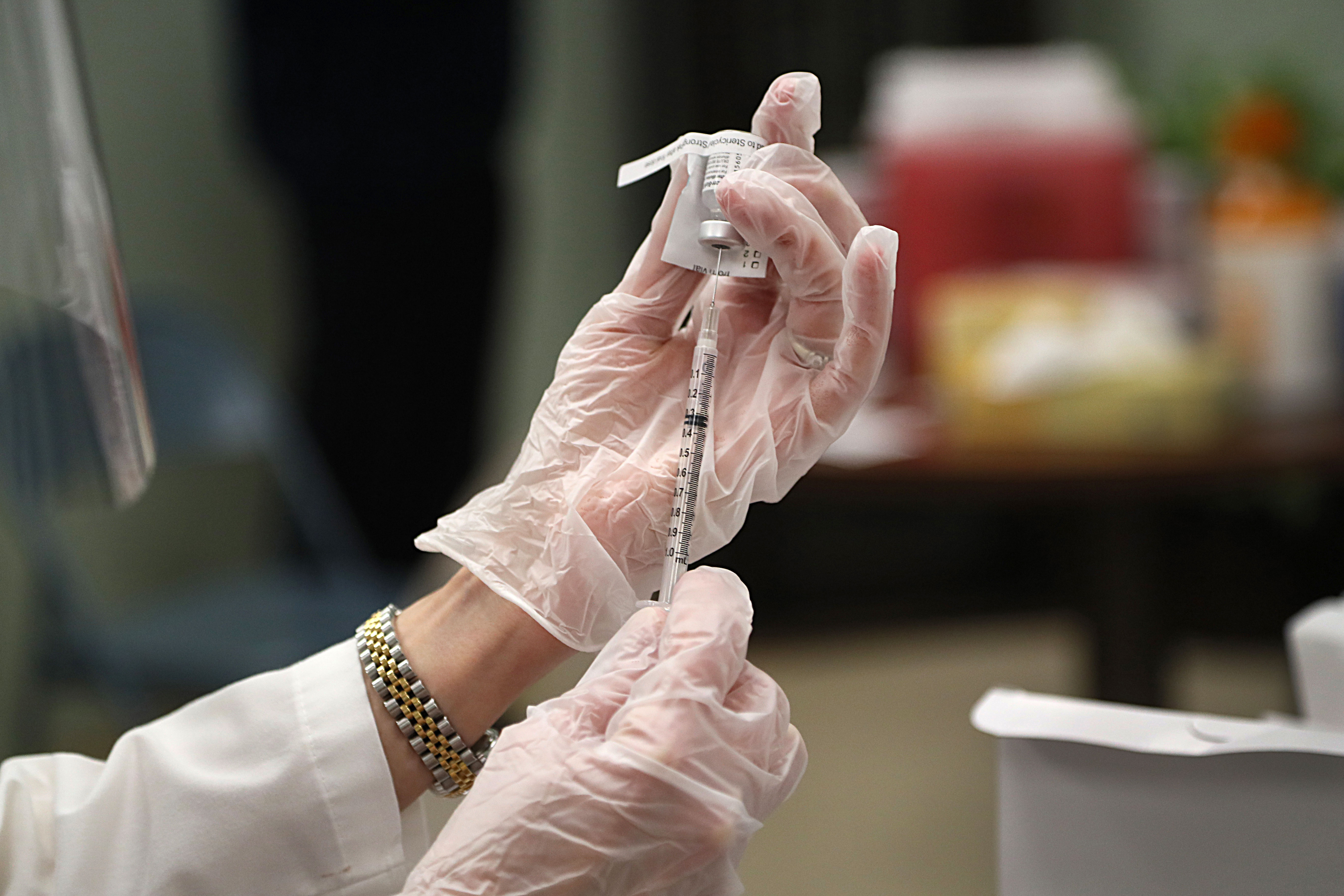 A Pfizer Covid-19 vaccine is prepared for staff at a skilled nursing and rehabilitation center in Acton, Massachusetts, on December 28.