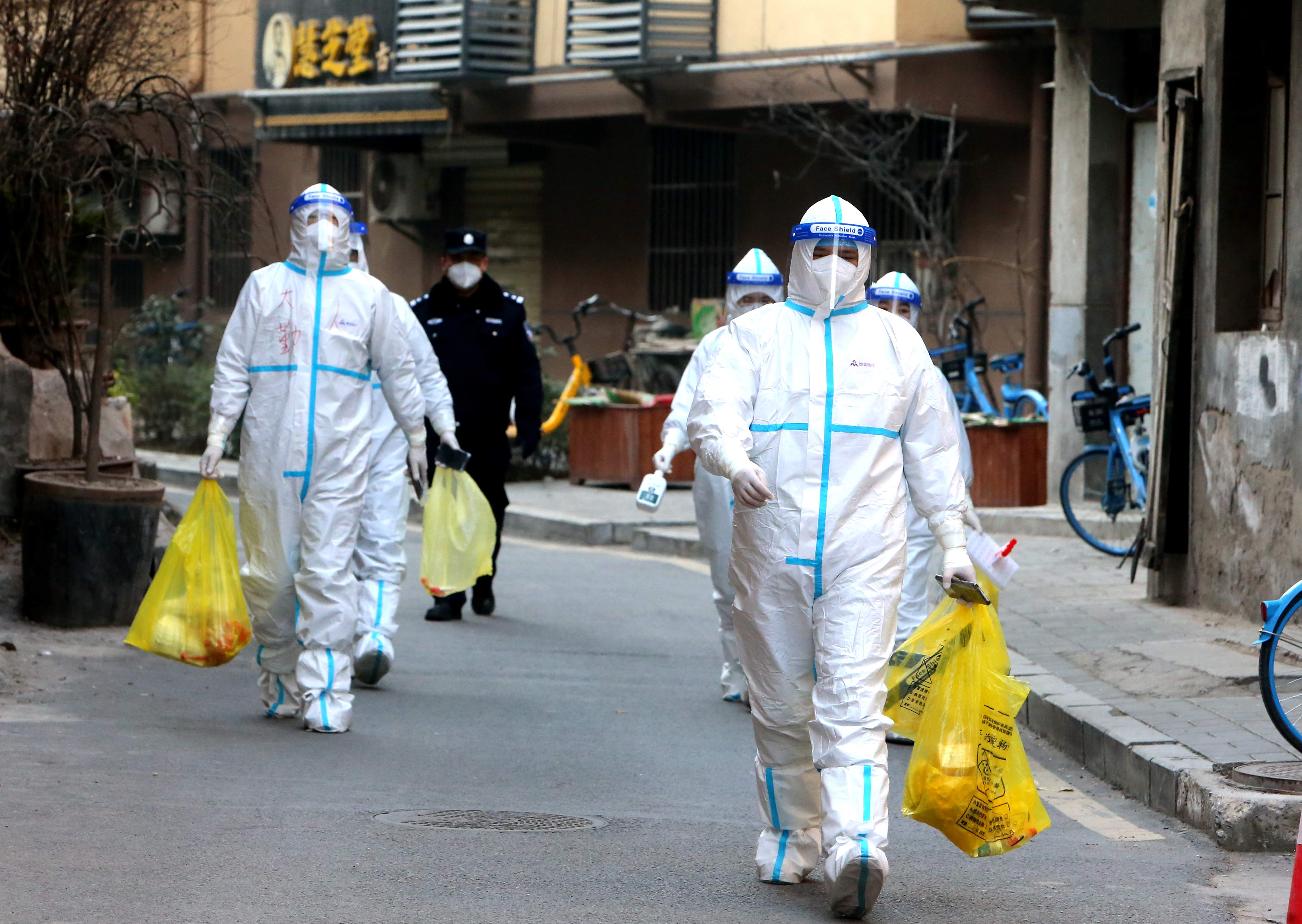Staff members in protective suits conduct COVID-19 nuclei acid tests at a residential area on January 2, 2021 in Xi'an, Shaanxi Province of China. 