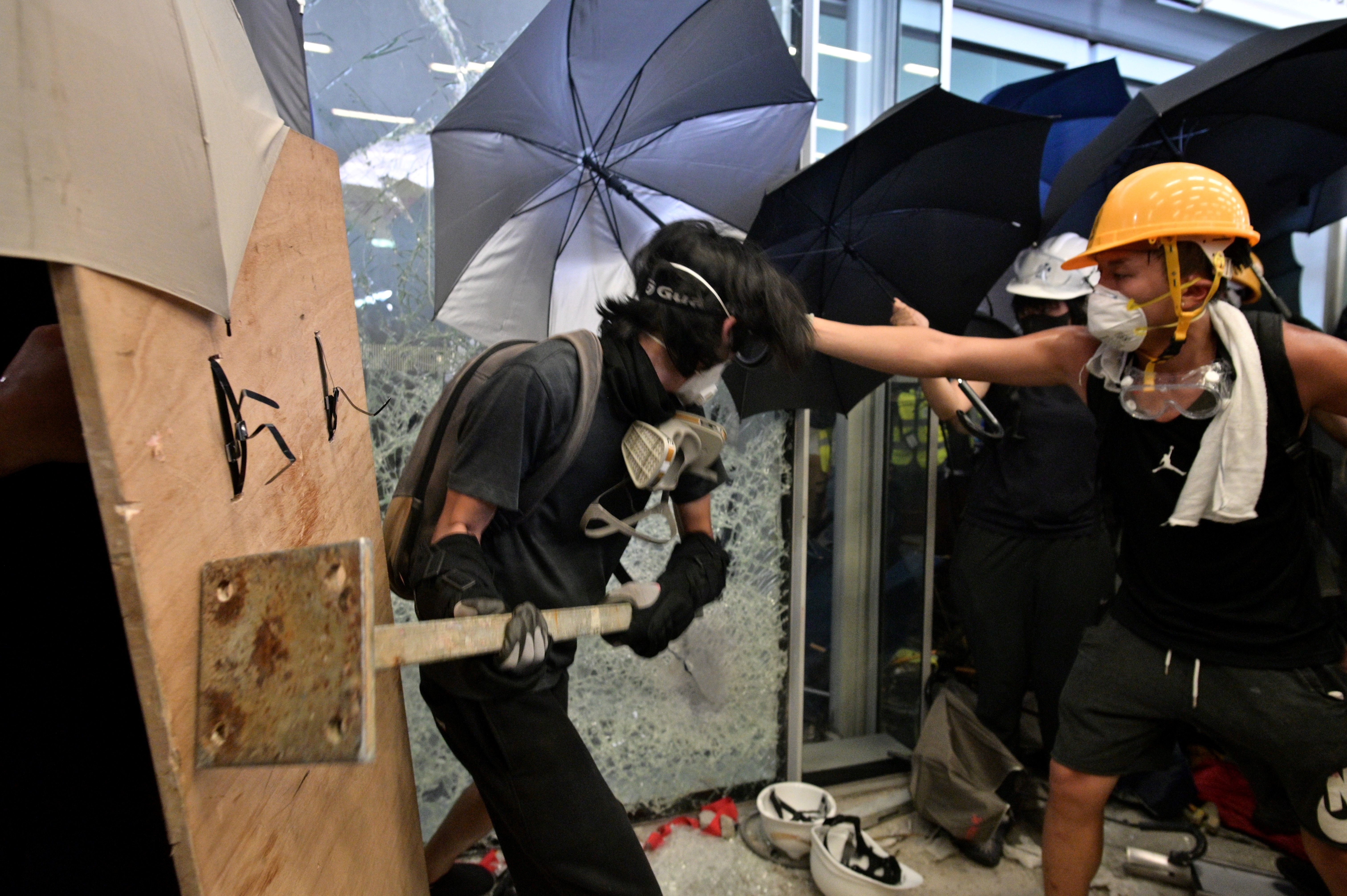 Protesters attempt to smash a glass door at the government headquarters in Hong Kong on July 1.