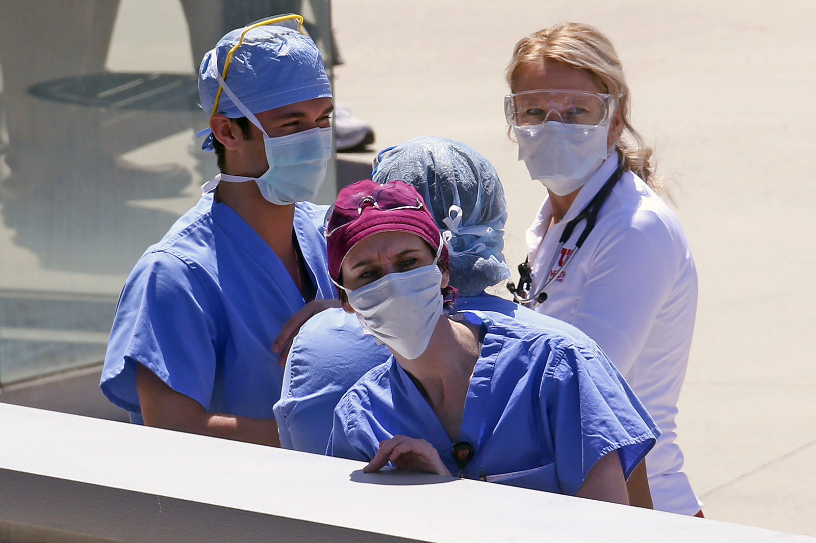 In this Thursday, April 30, file photo, health care workers look on during a flyover at the University of Utah Hospital in Salt Lake City. 