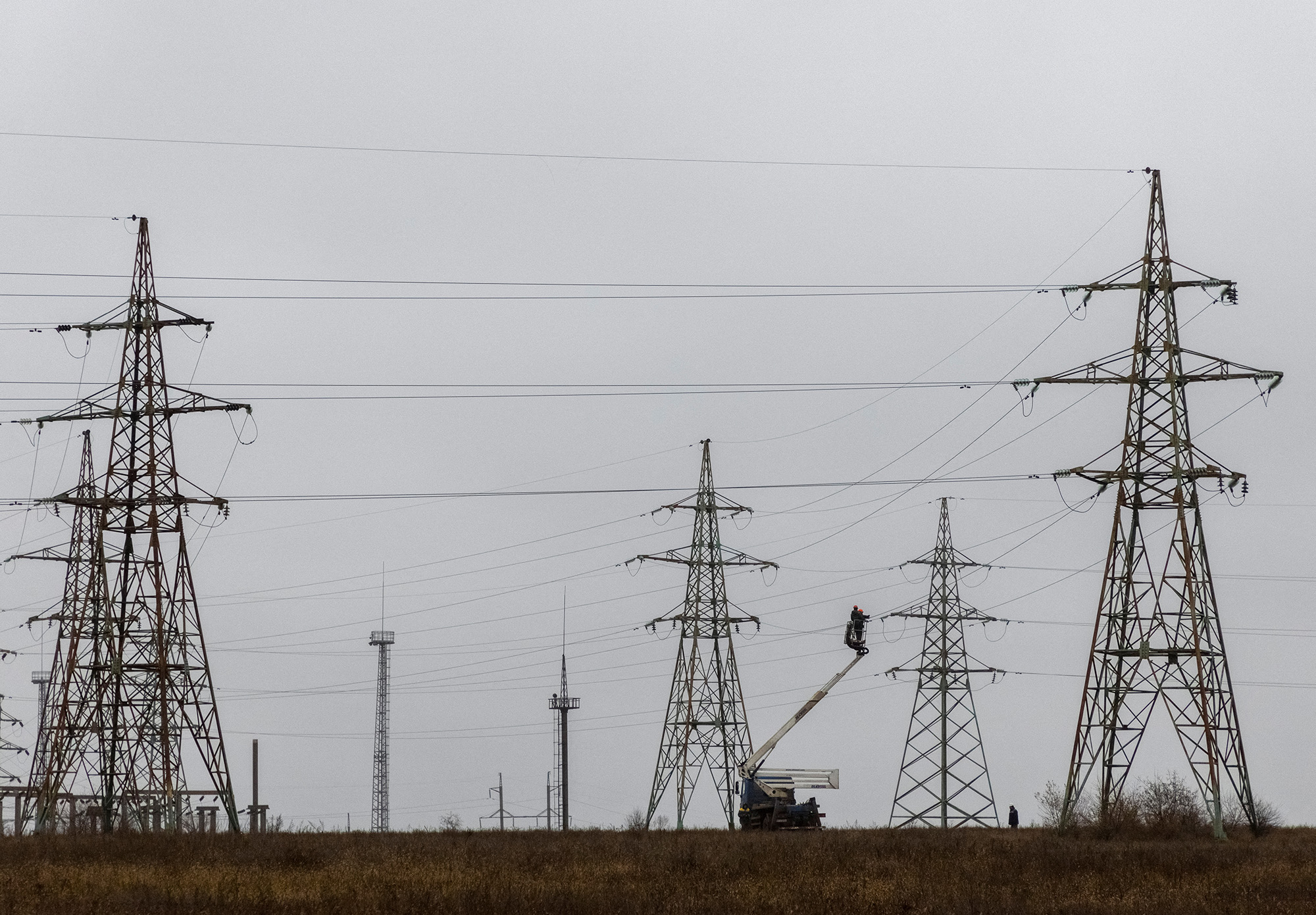 Employees remain electric power lines damaged by Russian military strikes in the Kherson region, Ukraine, on November 30.
