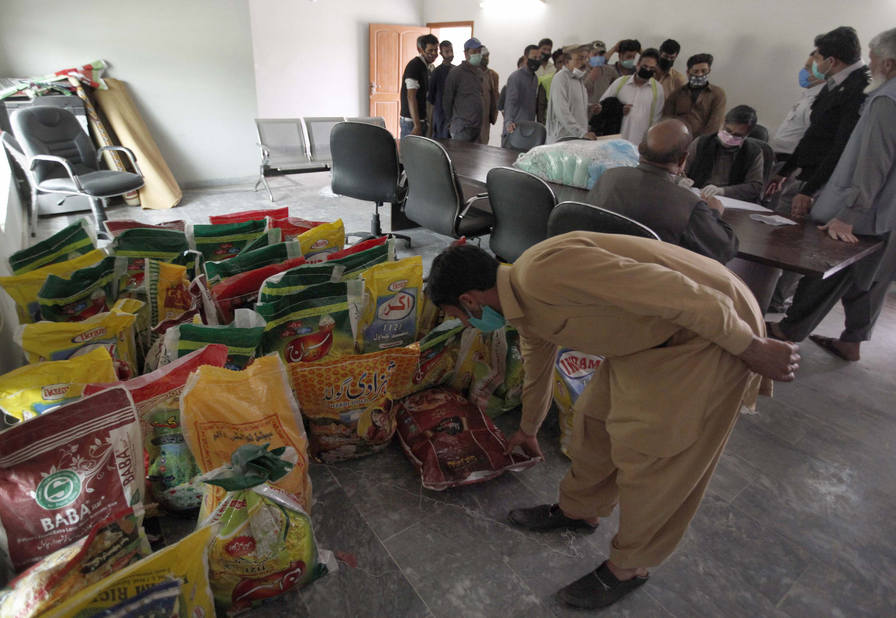 Daily wage workers receive food supplies during lockdown in Islamabad, Pakistan, on April 6.