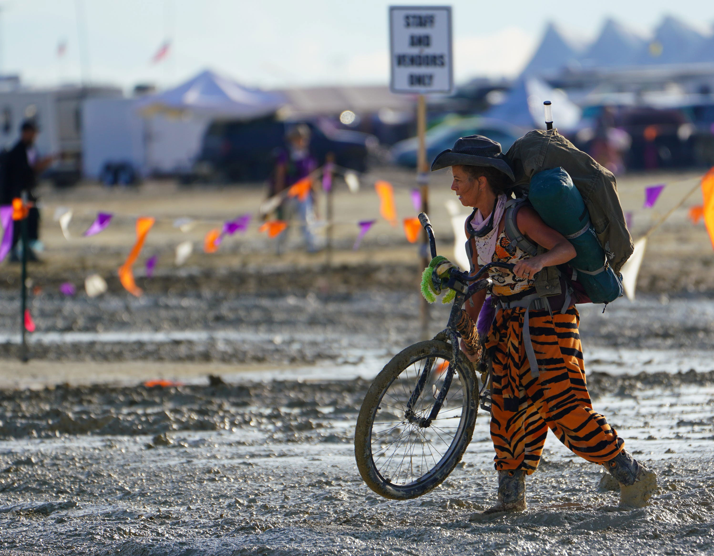 A Burning Man attendee walks their bike through the mud near the exit Sunday, September 3. 