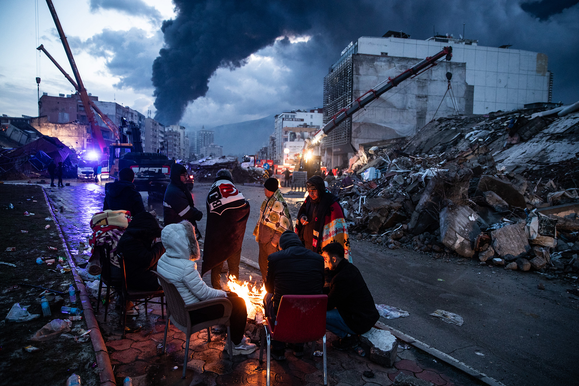 Survivors huddle around a fire as they wait for news of their loved ones in Iskenderun, Turkey.