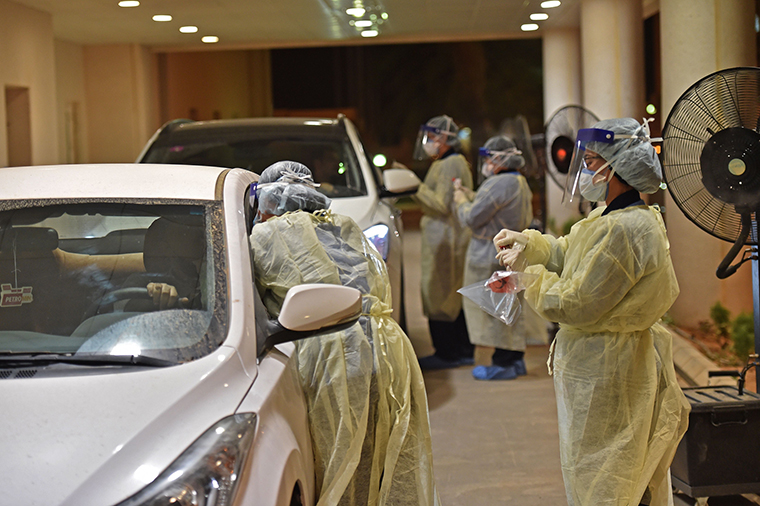 Health workers perform a nose swab test during a drive through coronavirus test campaign held in Diriyah hospital in the Saudi capital Riyadh on May 7.