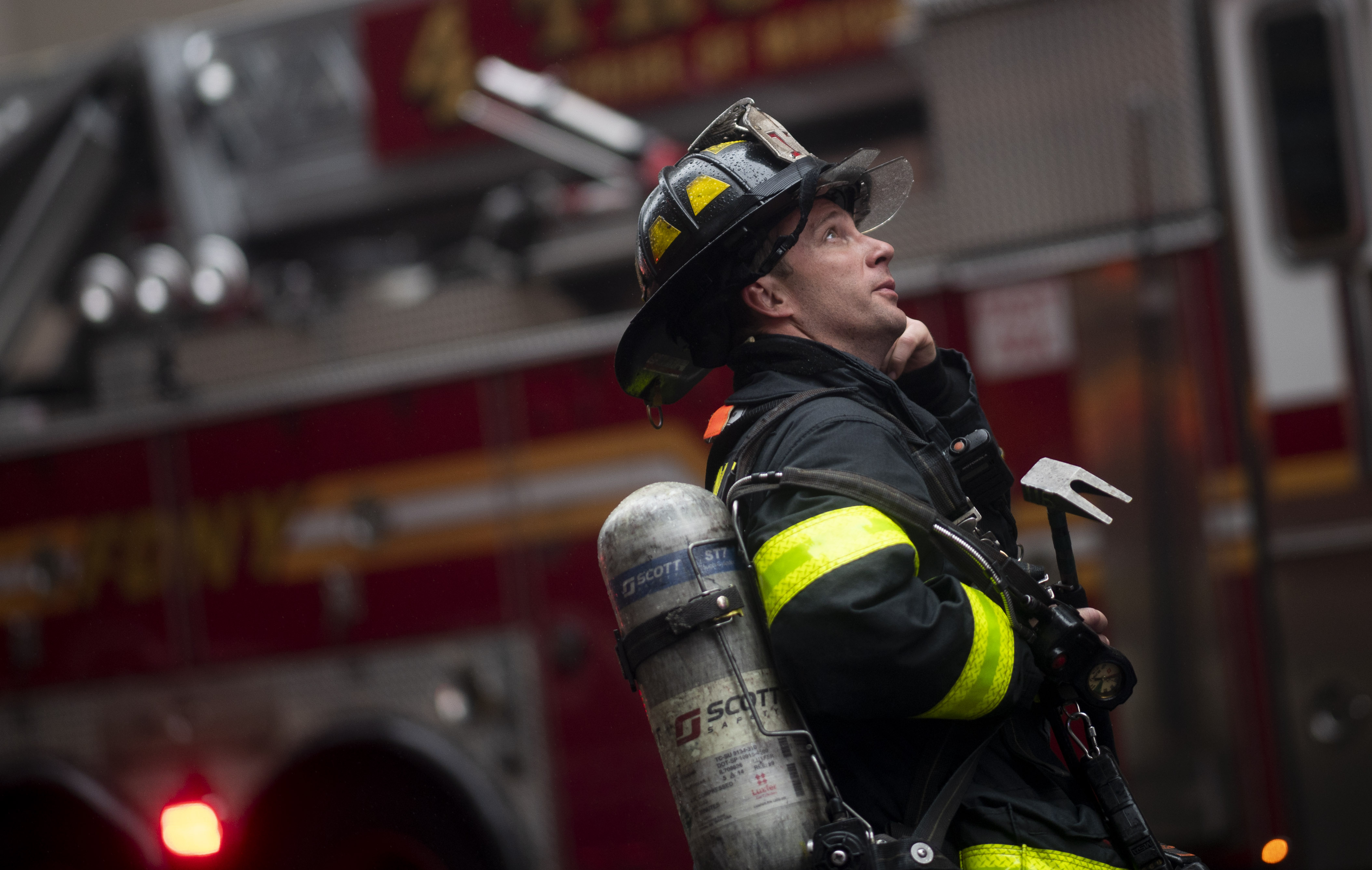 A firefighter looks up near a building where a helicopter crash-landed in midtown Manhattan in New York on June 10, 2019. 
